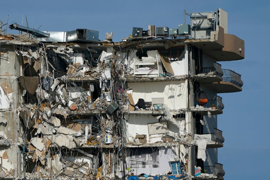 Furniture and household items are perched in the remains of destroyed apartments, in the still standing section of the Champlain Towers South condo building on Thursday, July 1, 2021, in Surfside, Fla. Scores of people remain missing one week after the building partially collapsed.(AP Photo/Mark Humphrey)