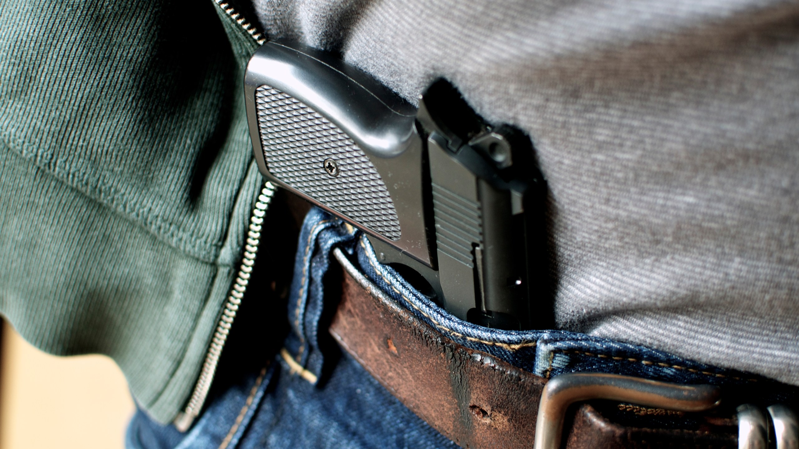 Pistol hidden in belt - stock photo