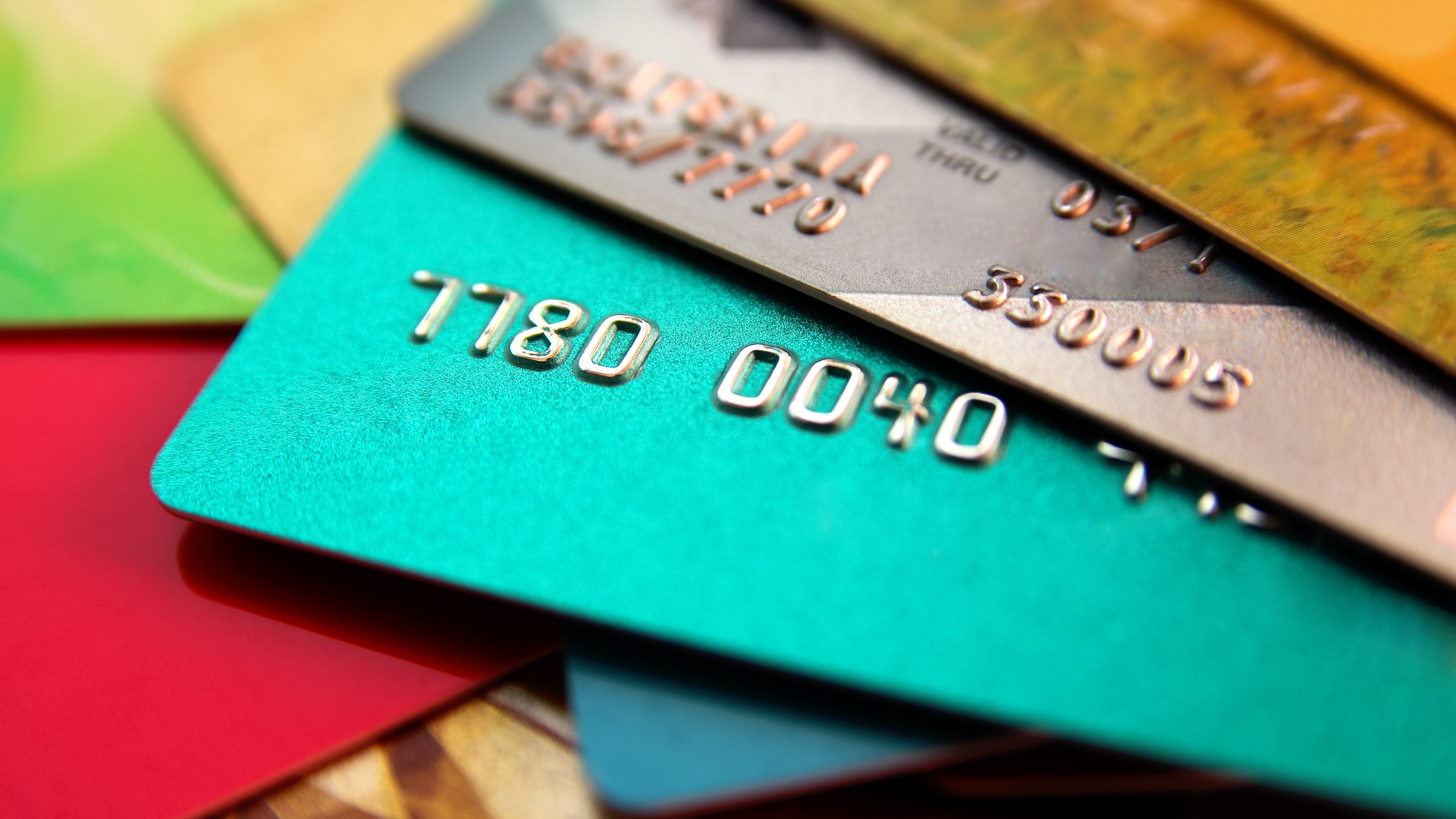 stack of multicolored credit cards, close up view with selective focus