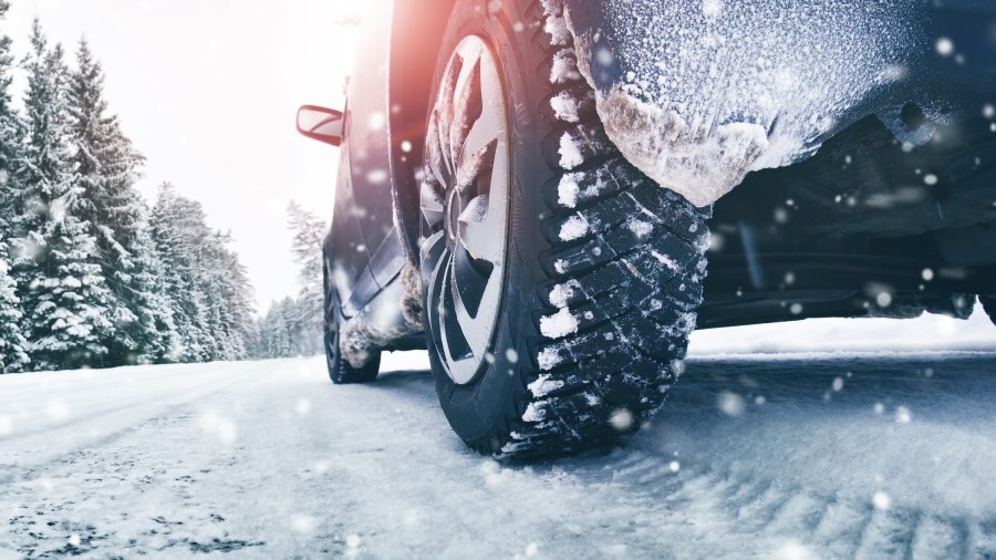 Closeup of car tires in winter on the road covered with snow