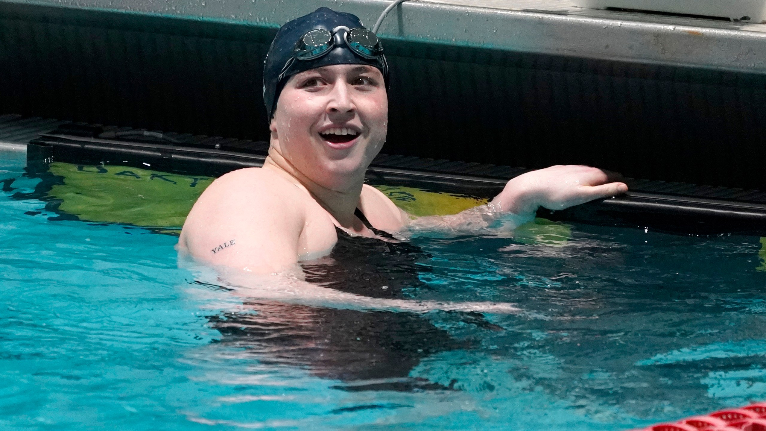 FILE - Yale's Iszac Henig, a trans man and competitive swimmer, looks up the scoreboard after swimming in a qualifying heat of the 100-yard freestyle at the Ivy League Women's Swimming and Diving Championships at Harvard University, Feb. 19, 2022, in Cambridge, Mass. Schools and colleges across the U.S. would be forbidden from enacting outright bans on transgender athletes under a proposal released Thursday, April 6, 2023, by the Biden administration, but teams could create some limits in certain cases — for example, to ensure fairness. (AP Photo/Mary Schwalm, File)