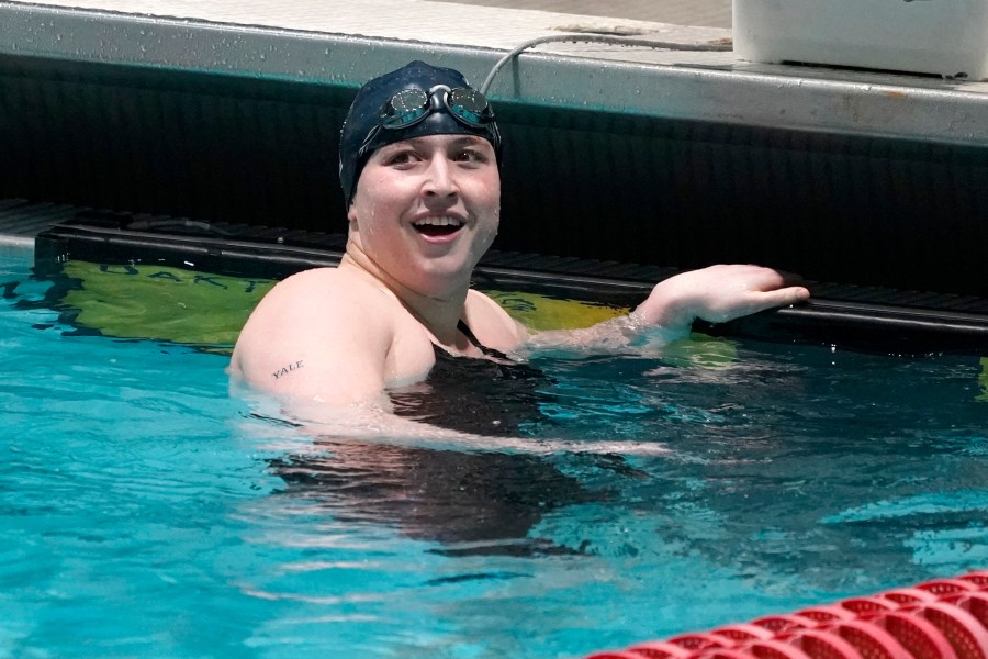 FILE - Yale's Iszac Henig, a trans man and competitive swimmer, looks up the scoreboard after swimming in a qualifying heat of the 100-yard freestyle at the Ivy League Women's Swimming and Diving Championships at Harvard University, Feb. 19, 2022, in Cambridge, Mass. Schools and colleges across the U.S. would be forbidden from enacting outright bans on transgender athletes under a proposal released Thursday, April 6, 2023, by the Biden administration, but teams could create some limits in certain cases — for example, to ensure fairness. (AP Photo/Mary Schwalm, File)