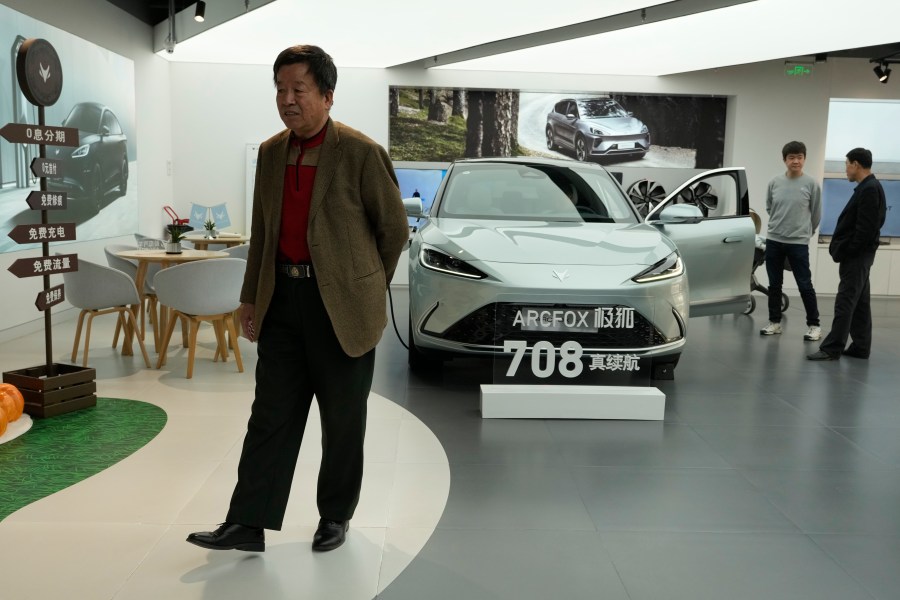 Visitors look at the Arcfox a-S, an all electric car from Chinese automaker BAIC which claims to have a 708km range on a single charge, at a show room in Beijing, Thursday, April 13, 2023. Global and Chinese automakers plan to unveil more than a dozen new electric SUVs, sedans and muscle cars this week at the Shanghai auto show, their first full-scale sales event in four years in a market that has become a workshop for developing electrics, self-driving cars and other technology. (AP Photo/Ng Han Guan)