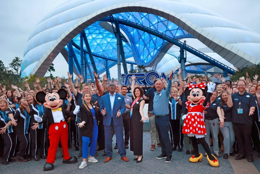 Mickey, Minnie and cast members join Walt Disney World executives in a ceremony marking the official opening of Tron Lightcycle / Run at the Magic Kingdom in Lake Buena Vista, Fla., on Monday, April 3, 2023. The roller coaster opens to guests on Tuesday. From left are Mickey Mouse; Ali Manion, Walt Disney World ambassador; Perry Crawley, Magic Kingdom operations general manager; Melissa Valiquette, vice president of Magic Kingdom; Jason Kirk, senior vice president of operations for Walt Disney World, Minnie Mouse. (Joe Burbank/Orlando Sentinel via AP)