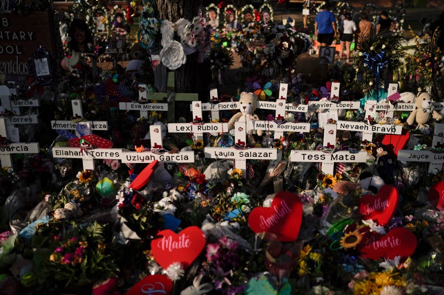 FILE - Flowers are piled around crosses with the names of the victims killed in a school shooting as people visit a memorial at Robb Elementary School to pay their respects May 31, 2022, in Uvalde, Texas. For the first time since the Uvalde school massacre, Texas Republican lawmakers on Tuesday, April 18, 2023, allowed proposals for stricter gun laws to get a hearing in the state Capitol — even though new restrictions have almost no chance of passing. (AP Photo/Jae C. Hong, File)