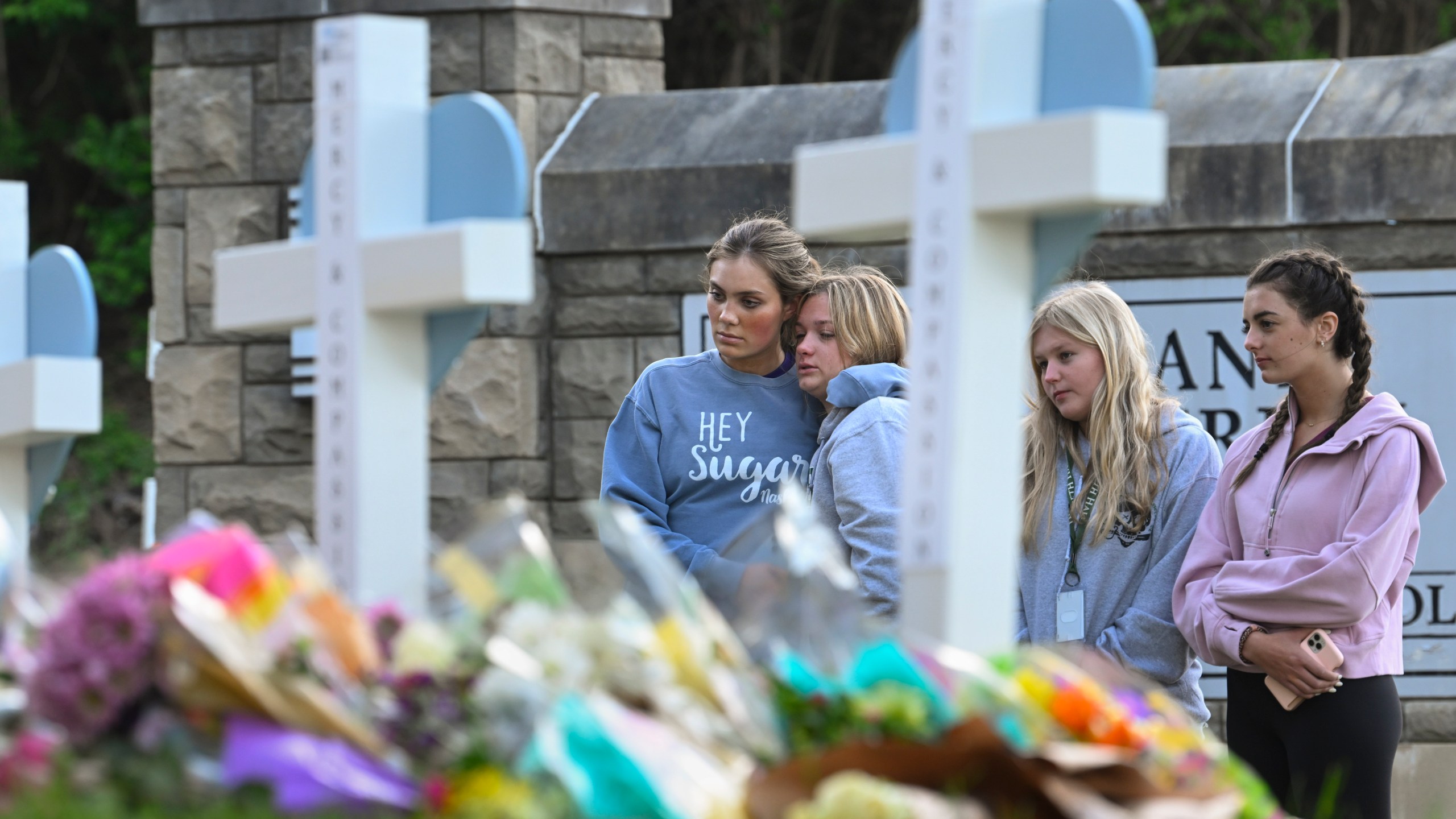 FILE - Students at a nearby school pay respects at a memorial for the people who were killed, at an entry to Covenant School, Tuesday, March 28, 2023, in Nashville, Tenn. Six people were killed at the private school and church yesterday by a shooter. The U.S. is setting a record pace for mass killings in 2023, replaying the horror in a deadly loop roughly once a week so far this year. The bloodshed overall represents just a fraction of the deadly violence that occurs in the U.S. annually. (AP Photo/John Amis, File)