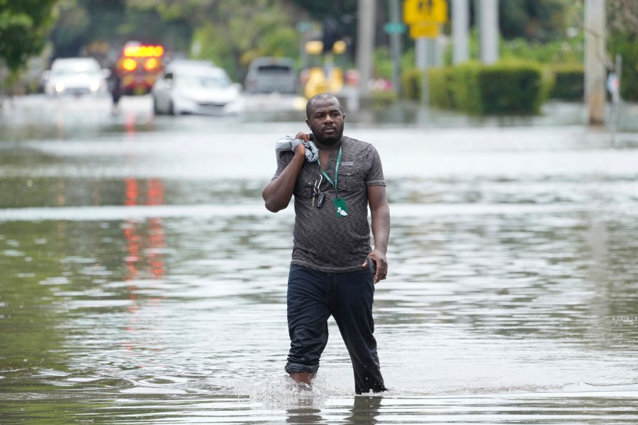 FILE - A man walks out of a flooded neighborhood Thursday, April 13, 2023, in Fort Lauderdale, Fla. Florida Gov. Ron DeSantis Saturday, April 22, 2023, is asking the Biden administration to declare Broward County a disaster area due to flooding earlier this month after record rainfall. (AP Photo/Marta Lavandier, File)