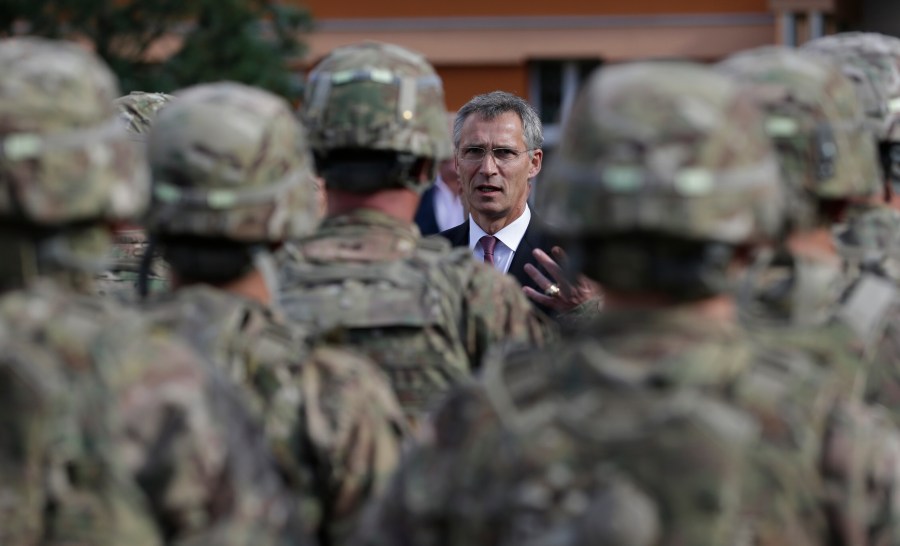 FILE - NATO Secretary General Jens Stoltenberg talks to US army soldiers while visiting Prague, Czech Republic, Wednesday, Sept. 9, 2015. On Wednesday April 26, 2023, the Czech government agreed to sign a defense military treaty with the United States. The treaty will set a legal framework for possible deployment of U.S. troops on Czech territory and their cooperation with the Czech armed forces. (AP Photo/Petr David Josek, File)