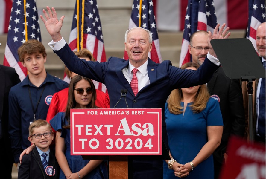 Former Arkansas Gov. Asa Hutchinson is surrounded by family members after formally announcing his Republican campaign for president, Wednesday, April 26, 2023, in Bentonville, Ark. (AP Photo/Sue Ogrocki)