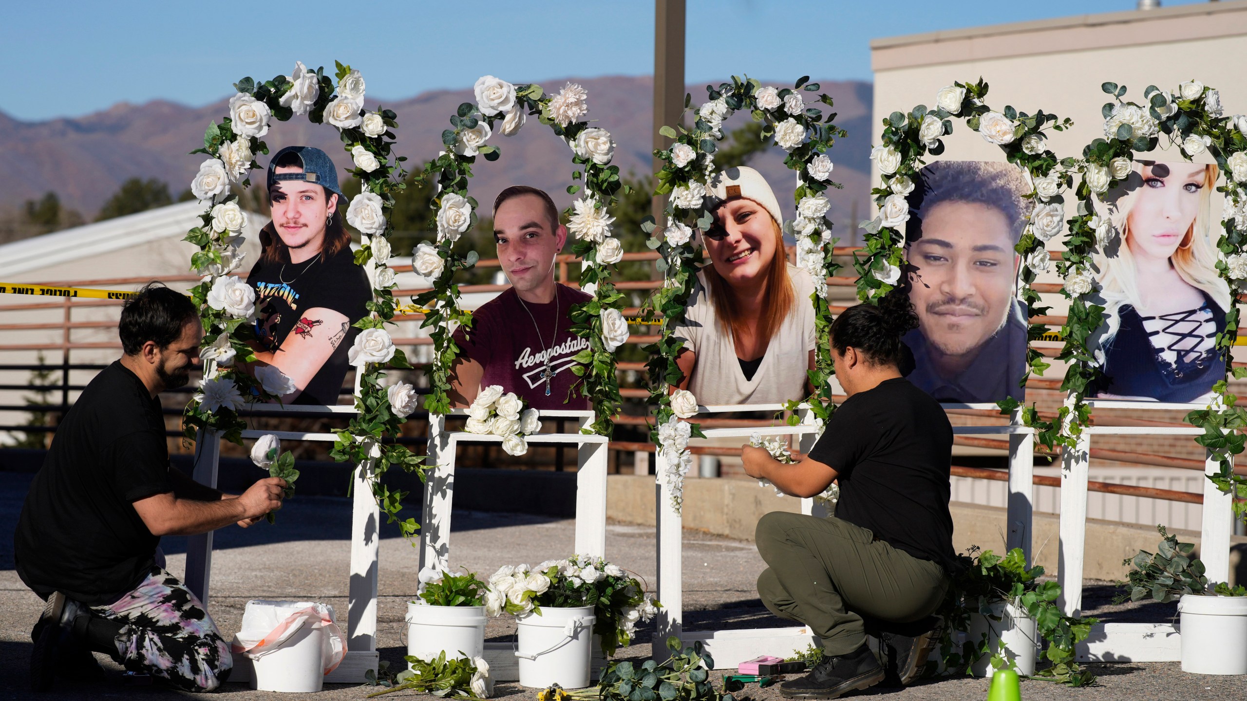 FILE - Noah Reich, left, and David Maldonado, the Los Angeles co-founders of Classroom of Compassion, put up a memorial Nov. 22, 2022, with photographs of the five victims of a weekend mass shooting at a nearby gay nightclub in Colorado Springs, Colo. Colorado’s governor signed four gun control bills Friday, April 28, 2023, edging the once-purple state closer to liberal-leaning governments in California and New York just months after a shooting at an LGBTQ nightclub in Colorado Springs, the latest in the state’s long history of notorious massacres. (AP Photo/David Zalubowski, File)