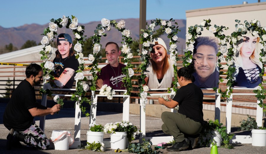 FILE - Noah Reich, left, and David Maldonado, the Los Angeles co-founders of Classroom of Compassion, put up a memorial Nov. 22, 2022, with photographs of the five victims of a weekend mass shooting at a nearby gay nightclub in Colorado Springs, Colo. Colorado’s governor signed four gun control bills Friday, April 28, 2023, edging the once-purple state closer to liberal-leaning governments in California and New York just months after a shooting at an LGBTQ nightclub in Colorado Springs, the latest in the state’s long history of notorious massacres. (AP Photo/David Zalubowski, File)