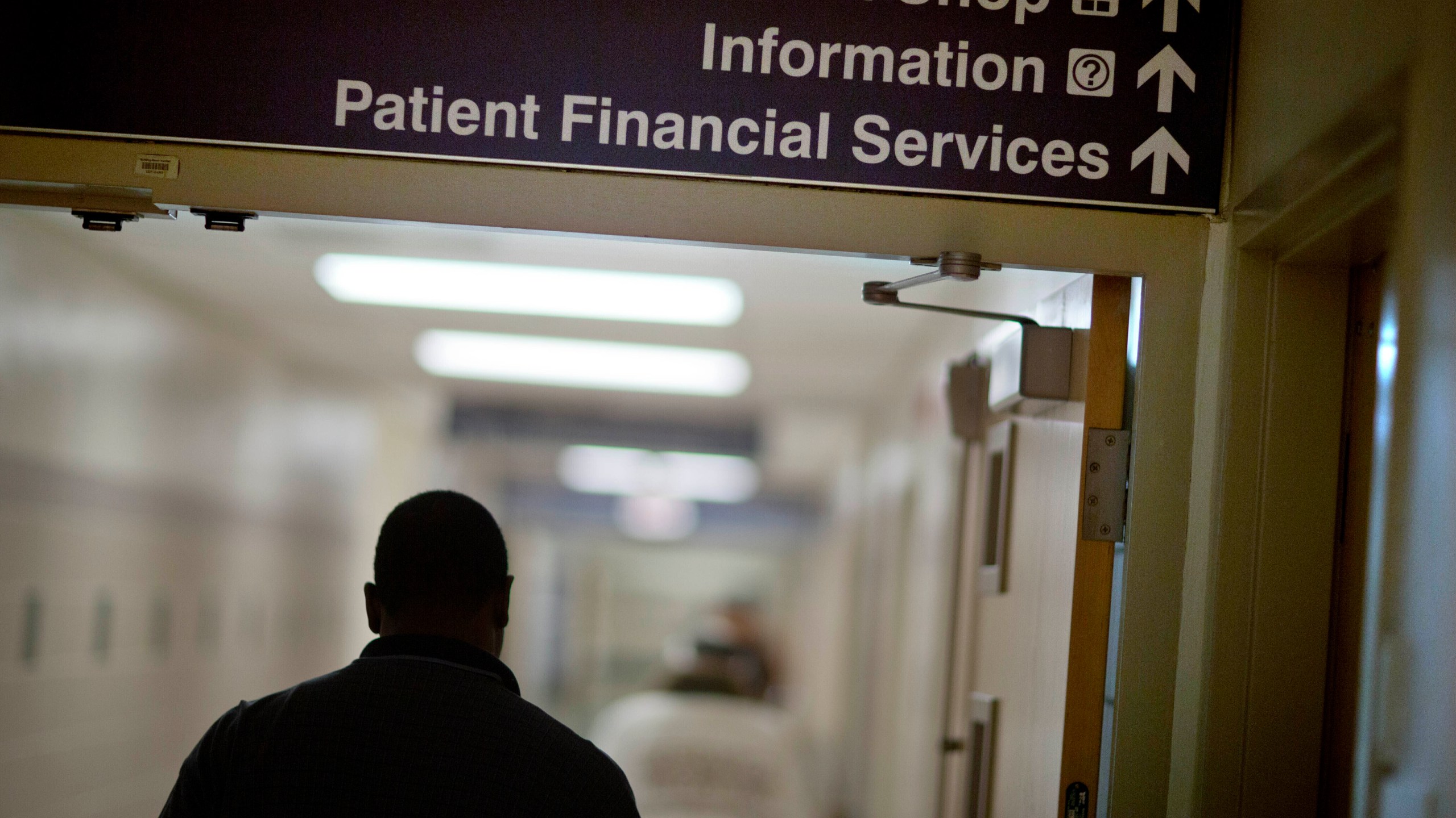 FILE - A sign points visitors toward the financial services department at a hospital, Friday, Jan. 24, 2014. More than a half million of the poorest Americans would be left without health insurance under legislation passed by House Republicans that would require people to work in exchange for health care coverage through Medicaid. The bill is unlikely to become law, though, with Democrats strongly opposing the idea. (AP Photo/David Goldman, File)