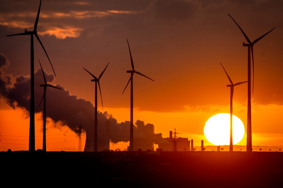 FILE - Steam rises from the coal-fired power plant near wind turbines Niederaussem, Germany, as the sun rises on Wednesday, Nov. 2, 2022. Germany has called for governments around the world to work on setting an ambitious target for renewable energy that would “ring in the end of the fossil fuel age” and help prevent dangerous global warming. (AP Photo/Michael Probst, File)