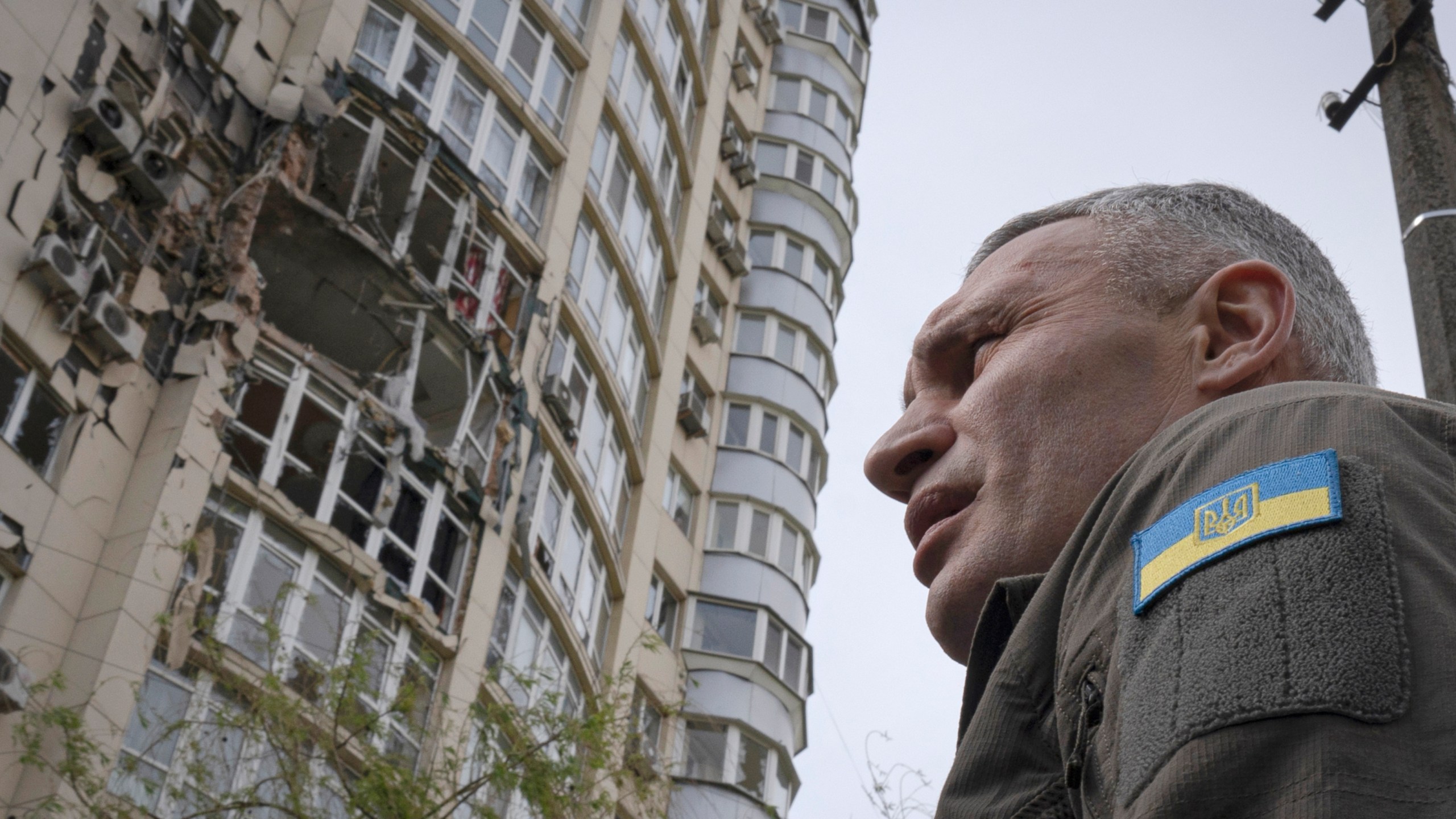 Kyiv Mayor Vitali Klitschko stands in front of an apartment building damaged by a drone that was shot down during a Russian overnight strike, amid Russia's attack, in Kyiv, Ukraine, Monday, May 8, 2023. (AP Photo/Andrew Kravchenko)