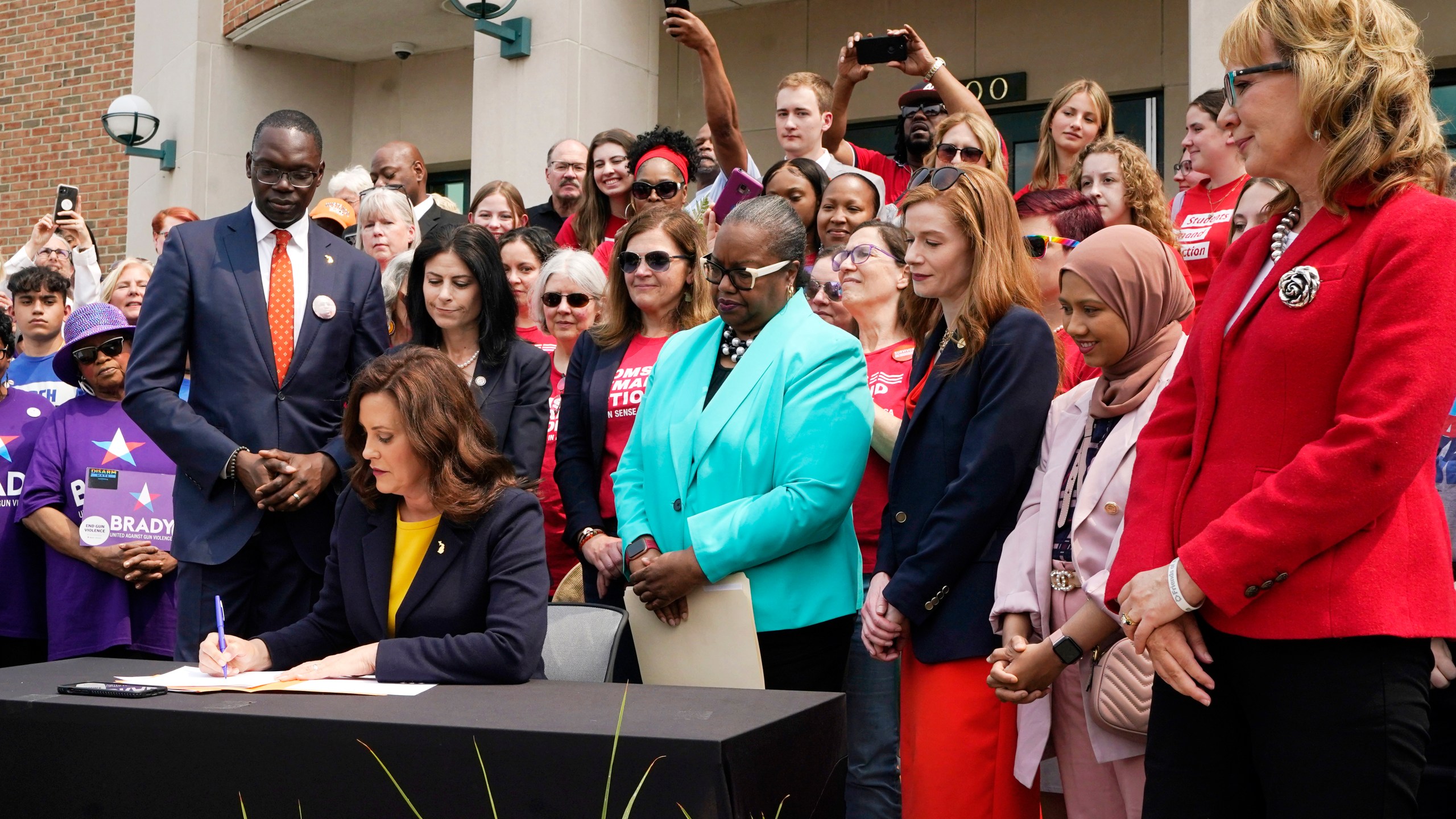 Michigan Gov. Gretchen Whitmer signs legislation, Monday, May 22, 2023, in Royal Oak, Mich. The package of legislation being signed will create extreme risk protection orders, which authorize family, police officers, or medical professionals to seek a court order to temporarily keep guns out of the hands of someone who represents a danger to themselves or others. (AP Photo/Carlos Osorio)