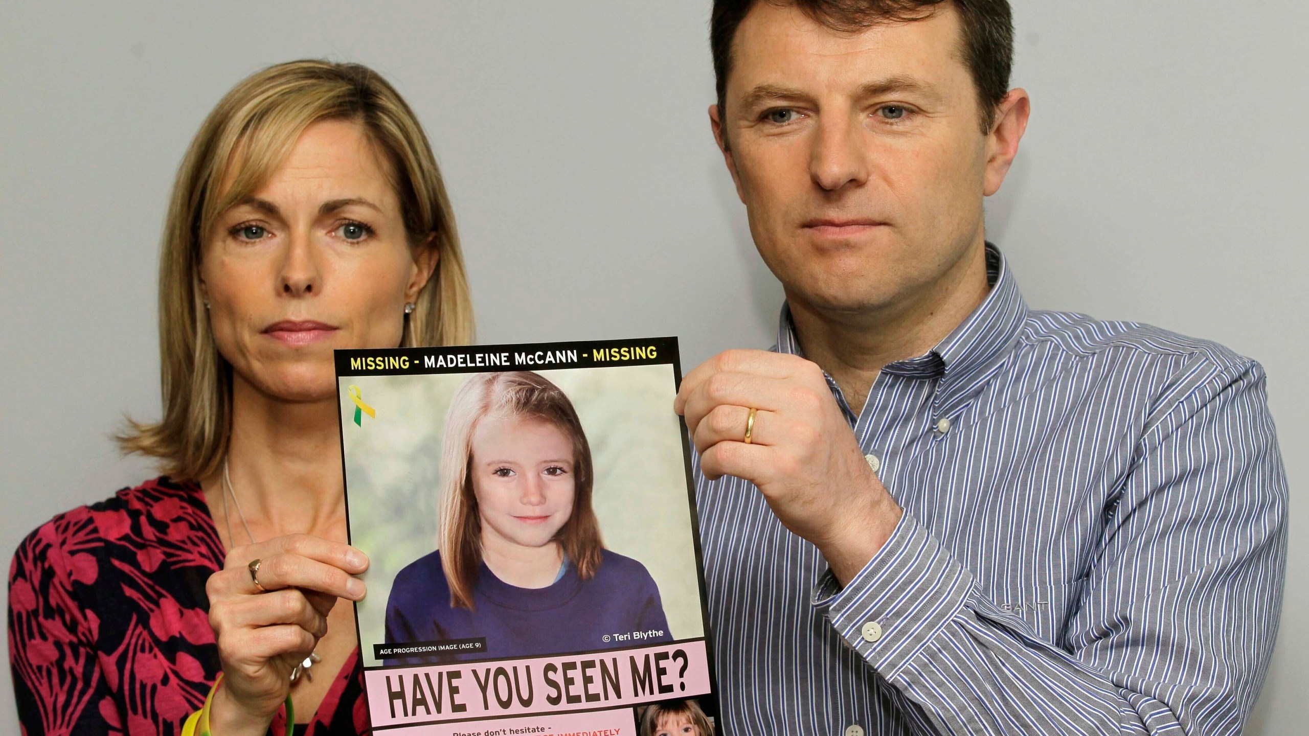 FILE - Kate and Gerry McCann pose for the media with a missing poster depicting an age progression computer generated image of their still missing daughter Madeleine during a news conference in London, May 2, 2012. Portuguese police say they'll resume searching for Madeleine McCann, the British toddler who disappeared in the country’s Algarve region in 2007, in the next few days.Portugal's Judicial Police released a statement confirming local media reports that they would conduct the search at the request of the German authorities and in the presence of British officials. (AP Photo/Sang Tan, File)