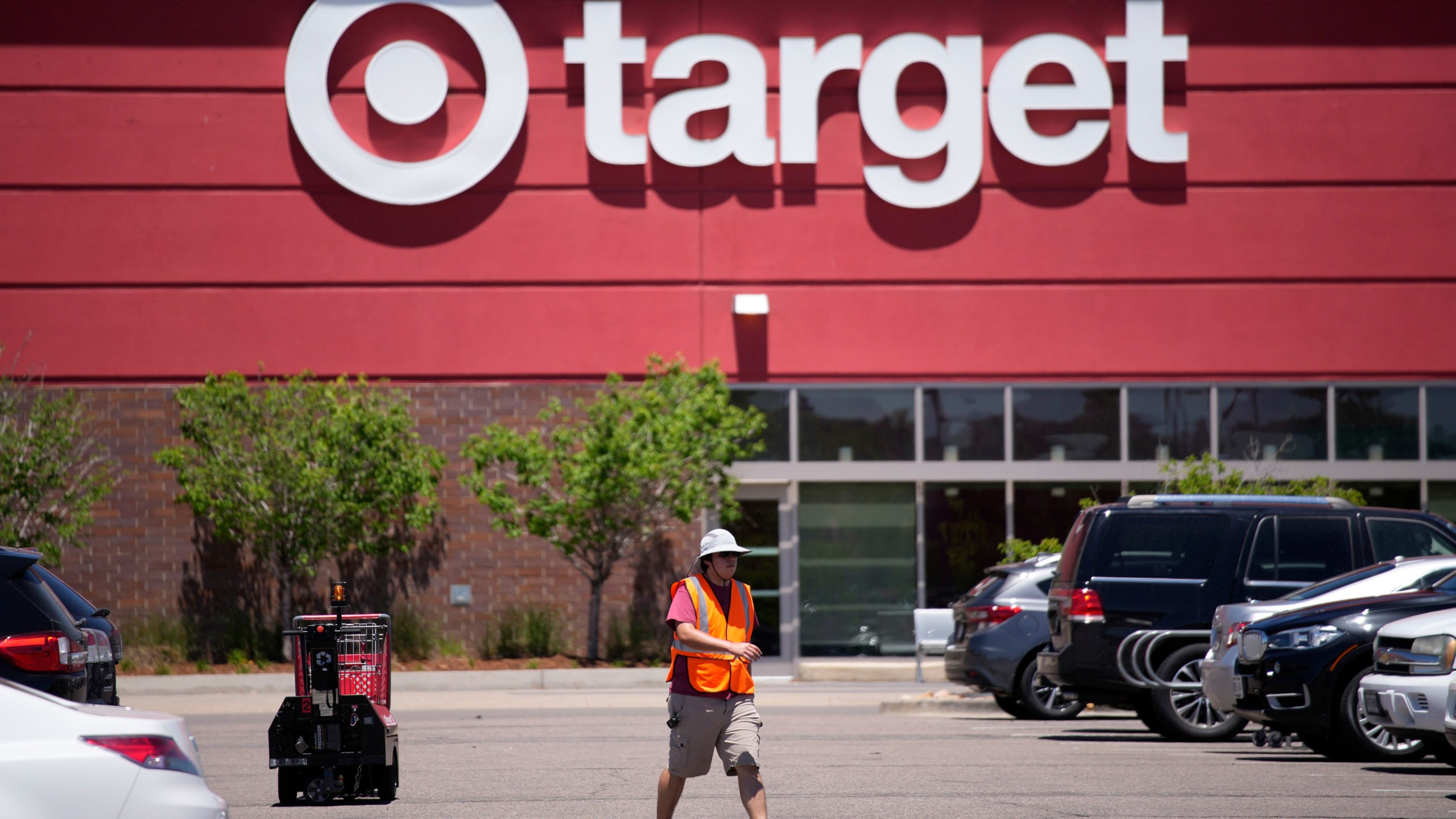 FILE - A worker collects shopping carts in the parking lot of a Target store on June 9, 2021, in Highlands Ranch, Colo. Target is removing certain items from its stores and making other changes to its LGBTQ merchandise nationwide ahead of Pride month, after an intense backlash from some customers including violent confrontations with its workers. (AP Photo/David Zalubowski, File)