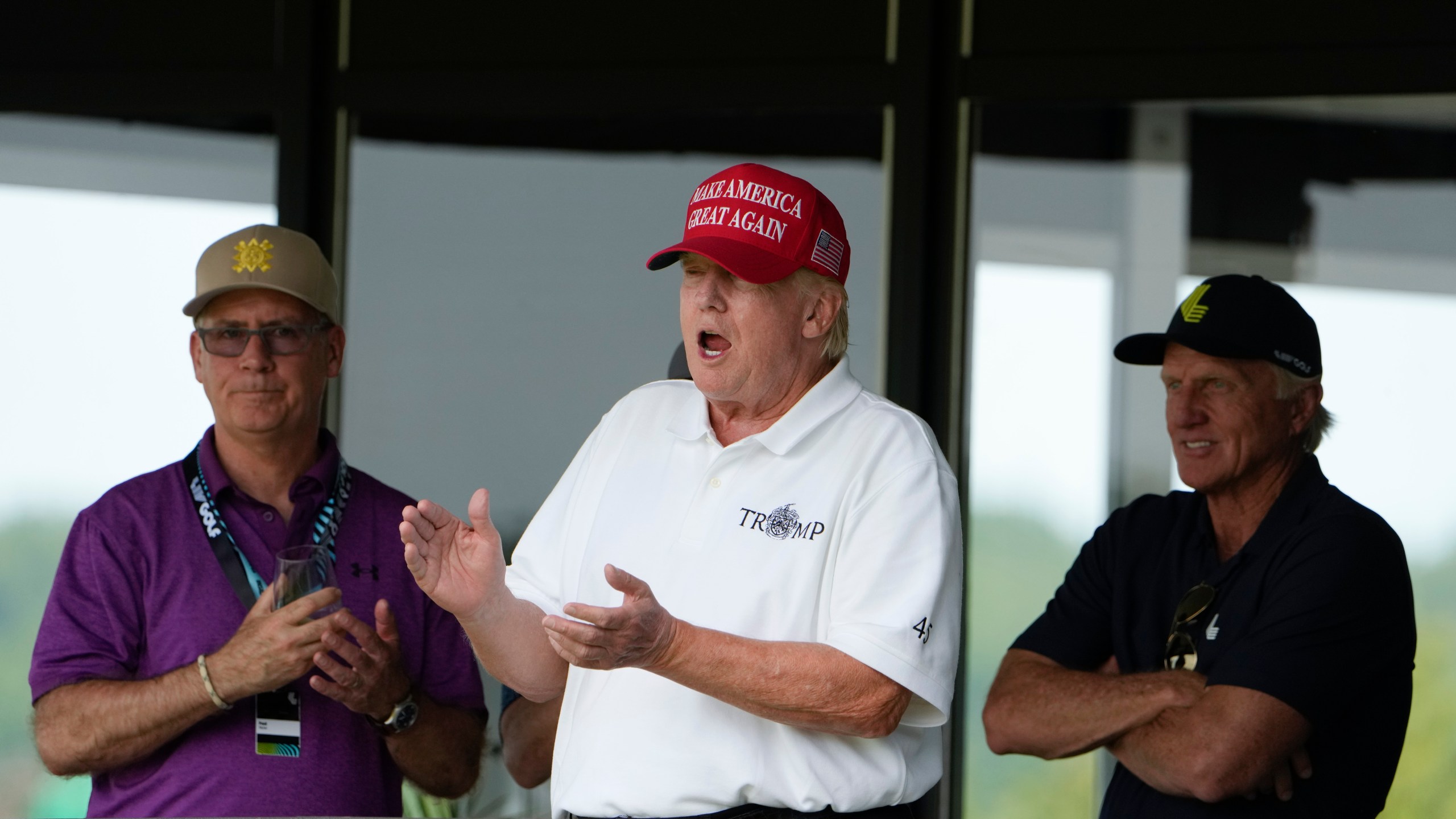 Former President Donald Trump, Greg Norman, LIV Golf CEO, right, and Paul Myler, deputy head of mission for the Australian Embassy in Washington, left, watch the second round of the LIV Golf at Trump National Golf Club, Saturday, May 27, 2023, in Sterling, Va. (AP Photo/Alex Brandon)