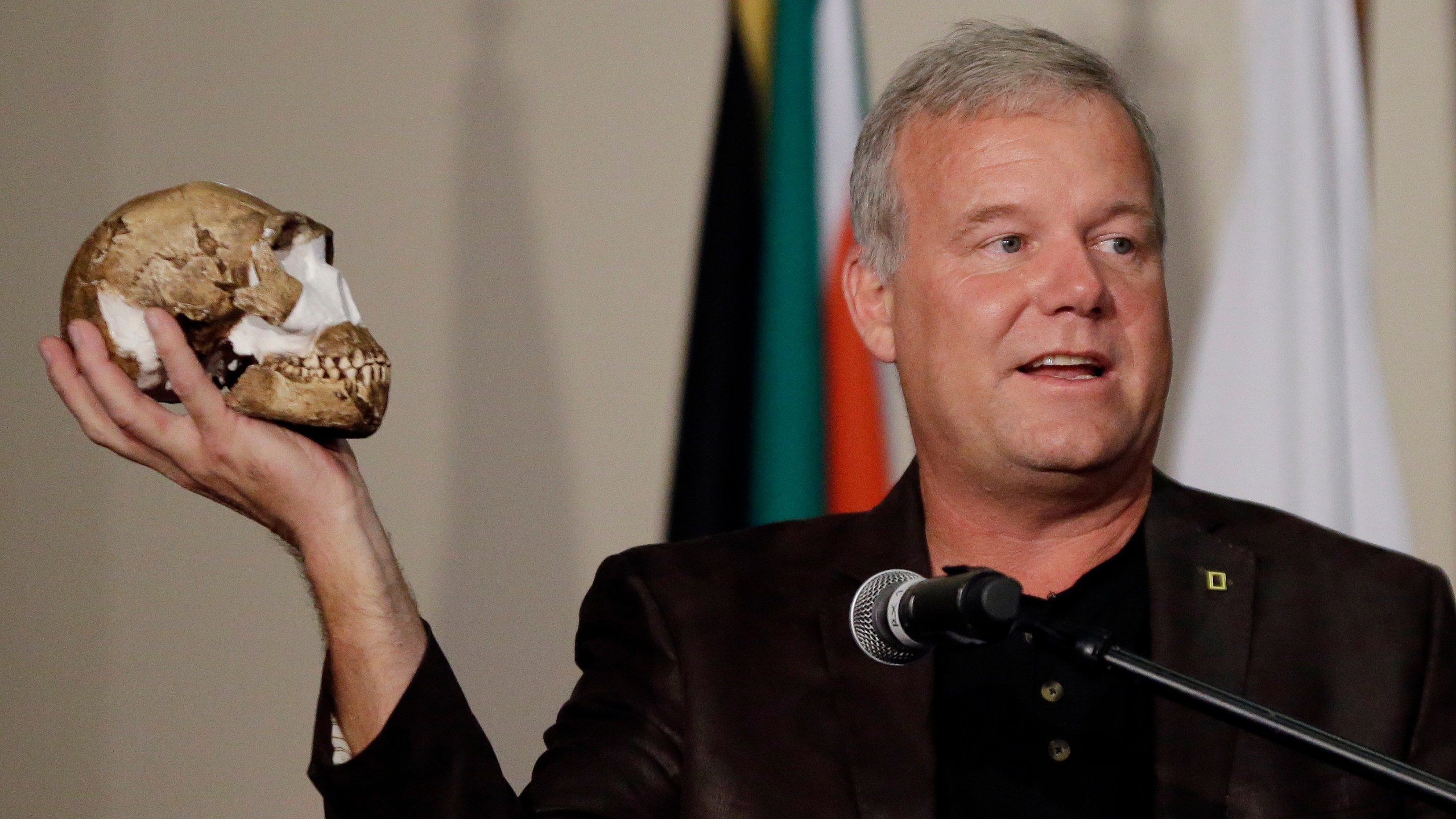 FILE - Researcher Lee Berger holds a reconstruction of the skull of Homo naledi at Magaliesburg, South Africa, Thursday, Sept. 10, 2015. In research released on Monday, June 5, 2023, scientists say they've found evidence that the ancient human cousin buried its dead and carved symbols into cave walls, actions previously tied only to bigger-brained species. (AP Photo/Themba Hadebe)