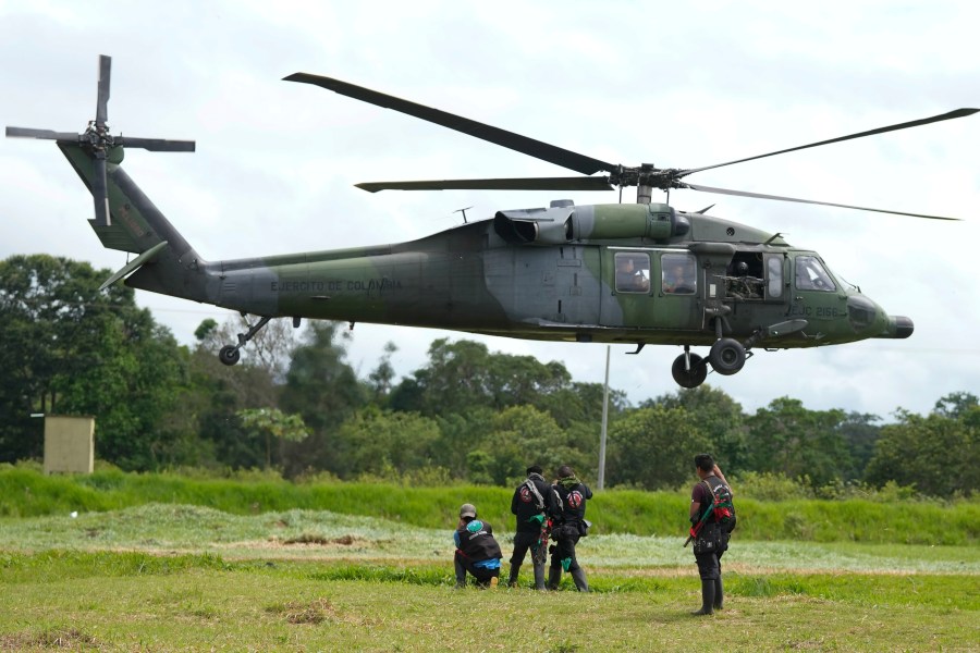 A military helicopter takes off with a group of Indigenous at a military base in Calamar, Colombia, Tuesday, May 23, 2023, to help search for four Indigenous children who are missing after a deadly plane crash. The May 30 discovery of footprints of a small foot rekindled the hope of finding the children alive after their plane crashed on May 1. Soldiers found the wreckage and the bodies of three adults, including the pilot and the children's mother. (AP Photo/Fernando Vergara)