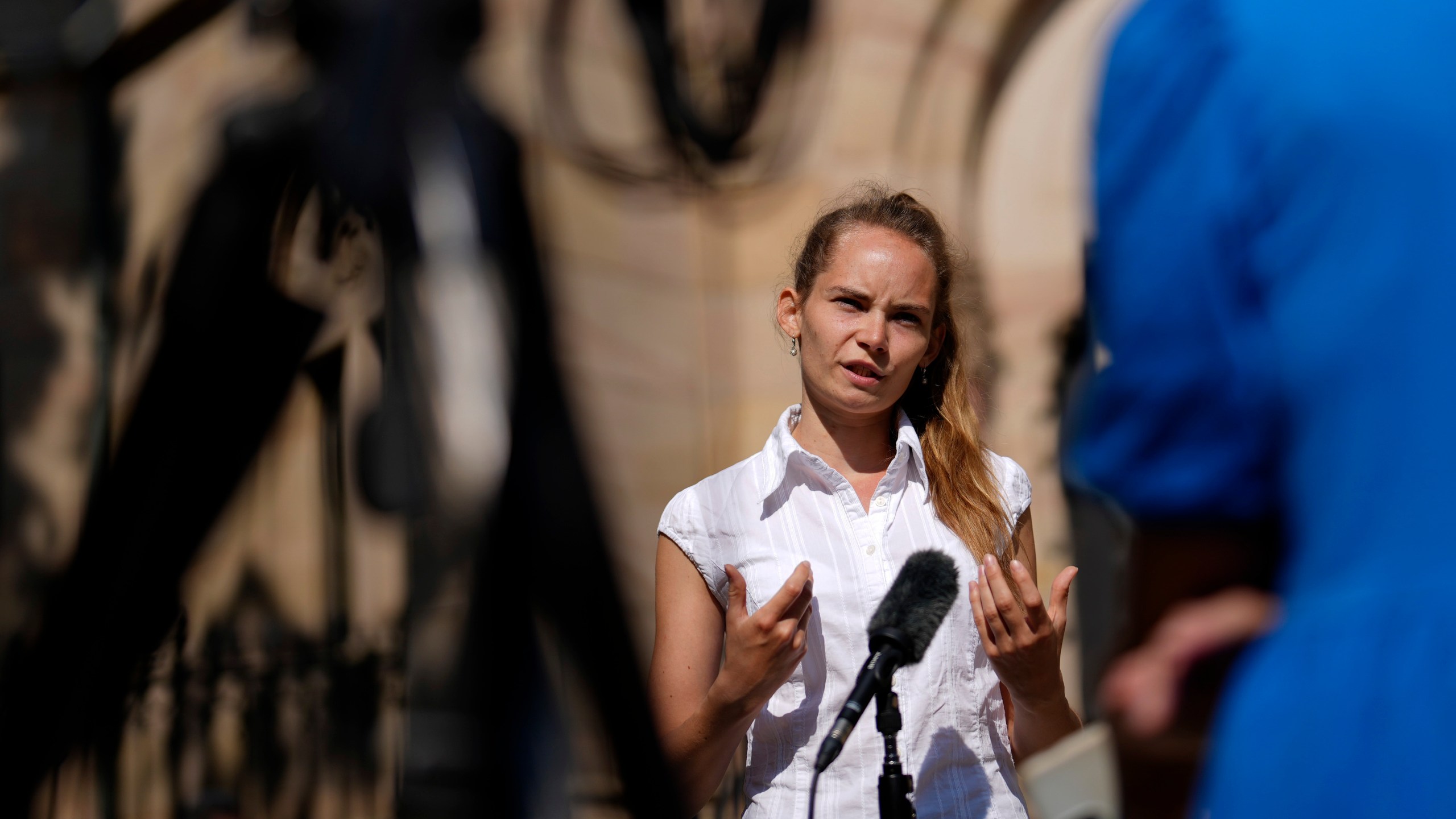 Anna Puzio, 28, researcher for ethics of technology at University of Twente, Netherlands, gestures during an interview with The Associated Press in Nuremberg, Germany, Friday, June 9, 2023. Hundreds of German Protestants have attended a church service in Bavaria that was generated almost entirely by artificial intelligence. The service was created by ChatGPT and Jonas Simmerlein, a theologian and philosopher from the University of Vienna. The ChatGPT chatbot, personified by different avatars on a huge screen above the altar, led the more than 300 people through 40 minutes of prayer, music, sermons and blessings. (AP Photo/Matthias Schrader)