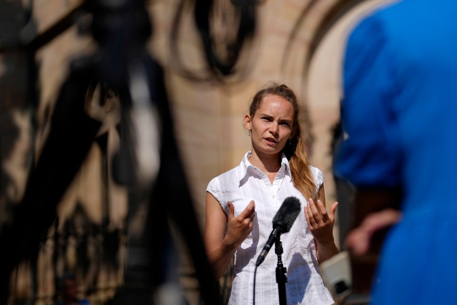 Anna Puzio, 28, researcher for ethics of technology at University of Twente, Netherlands, gestures during an interview with The Associated Press in Nuremberg, Germany, Friday, June 9, 2023. Hundreds of German Protestants have attended a church service in Bavaria that was generated almost entirely by artificial intelligence. The service was created by ChatGPT and Jonas Simmerlein, a theologian and philosopher from the University of Vienna. The ChatGPT chatbot, personified by different avatars on a huge screen above the altar, led the more than 300 people through 40 minutes of prayer, music, sermons and blessings. (AP Photo/Matthias Schrader)