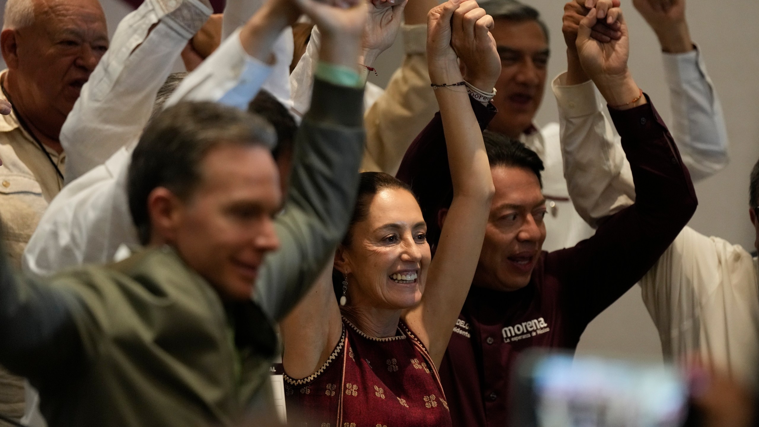 Ruling MORENA party presumptive presidential candidate and Mexico City's Mayor Claudia Sheinbaum, center, raises her arms during a news conference at a hotel in Mexico City, Sunday, June 11, 2023. President Andres Manuel Lopez Obrador's MORENA party announced the rules to be followed by its candidates for the presidential elections of 2024 and the date of the primary elections to determine who will get the party's nomination. (AP Photo/Fernando Llano)