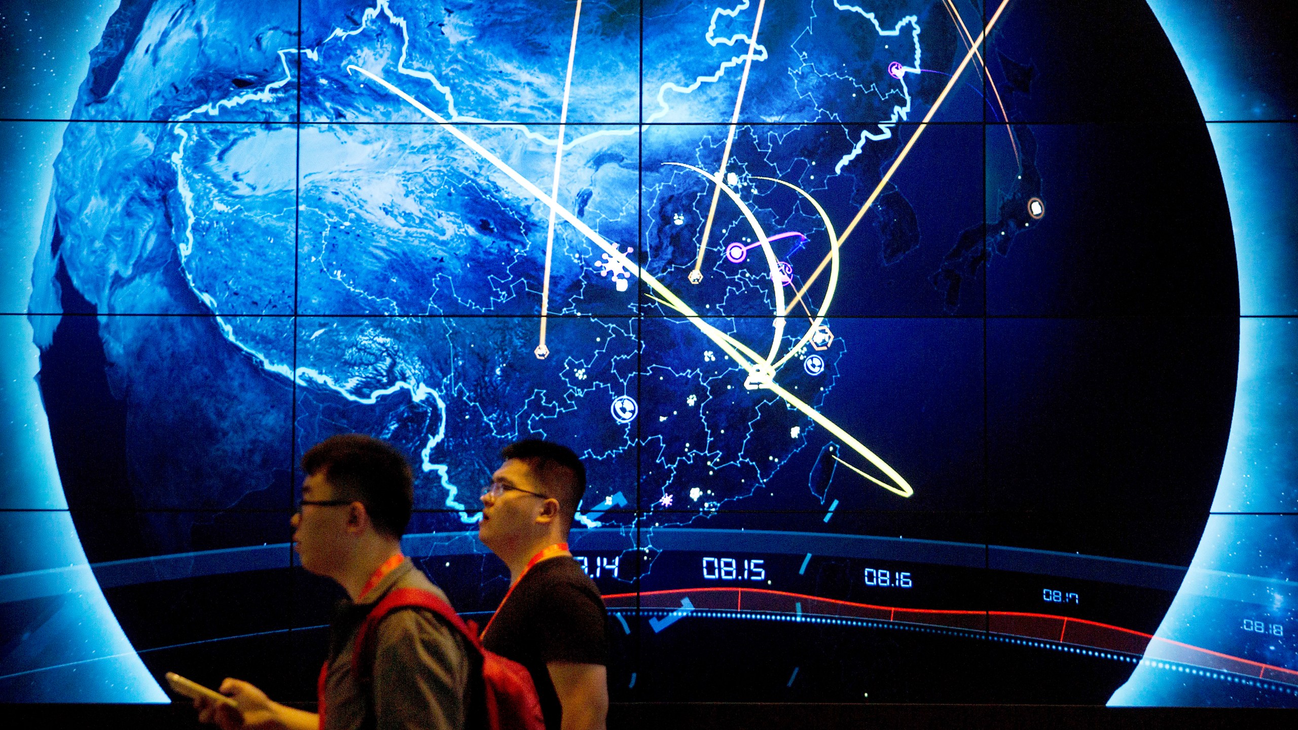 FILE - Attendees walk past an electronic display showing recent cyberattacks in China at the China Internet Security Conference in Beijing, on Sept. 12, 2017. Hackers linked to China were likely behind the exploitation of a software security hole in cybersecurity firm Barracuda Networks’ email security feature that affected public and private organizations globally, according to an investigation by security firm Mandiant. (AP Photo/Mark Schiefelbein, File)