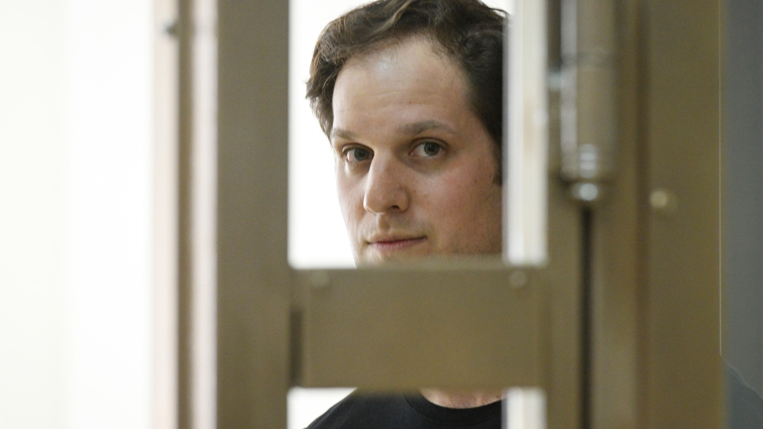 Wall Street Journal reporter Evan Gershkovich stands in a glass cage in a courtroom at the Moscow City Court in Moscow, Russia, Thursday, June 22, 2023. Gershkovich, a Wall Street Journal reporter detained on espionage charges in Russia, appeared in court Thursday to appeal his extended detention. (AP Photo/Dmitry Serebryakov)