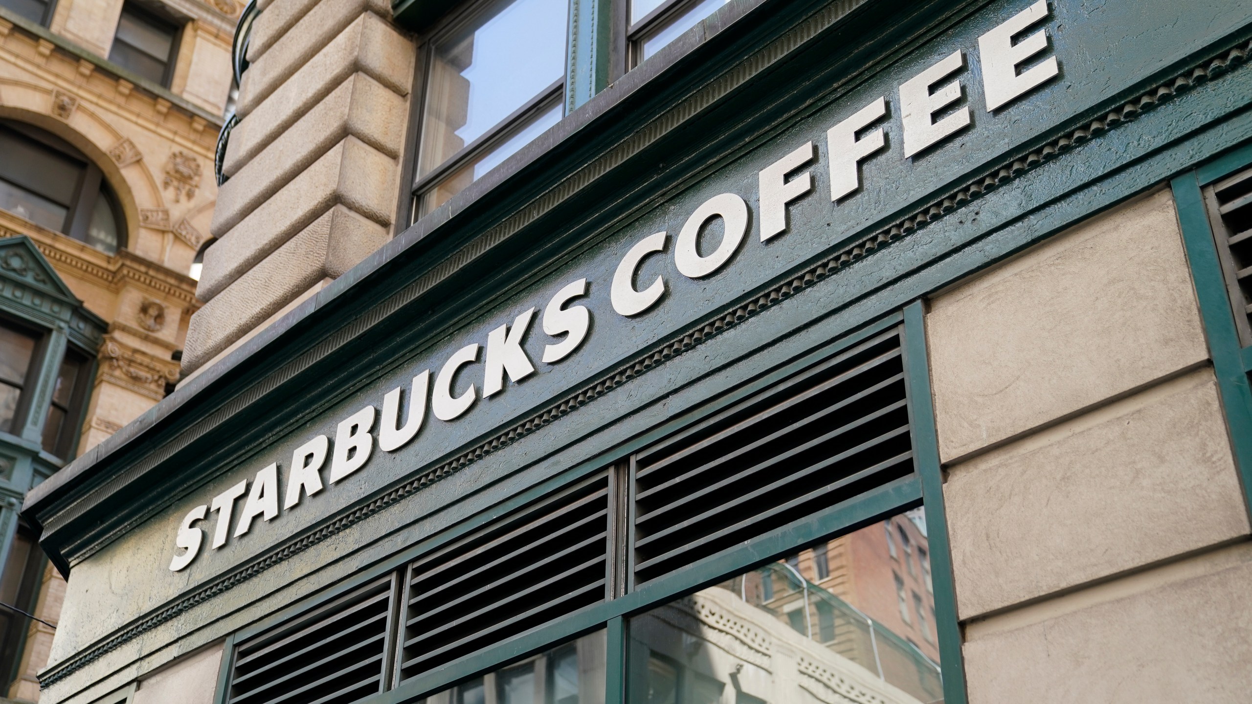 A Starbucks sign sits above a store in the Financial District of Lower Manhattan, Tuesday, June 13, 2023, in New York. Starbucks is denying union organizers' claims that it banned LGBTQ+ Pride displays in its U.S. stores after Target and other brands experienced backlash. The Seattle coffee giant says there has been no change to its policy and it encourages store leaders to celebrate Pride in June. (AP Photo/John Minchillo)