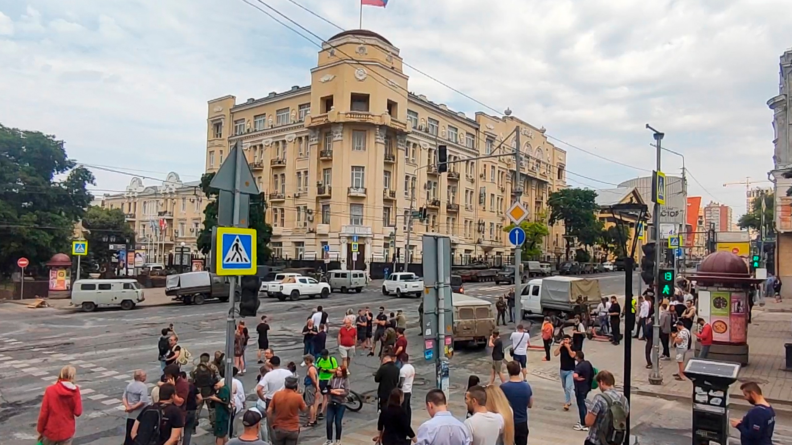 In this photo taken from video, people gather to look at military vehicles parked in a street in Rostov-on-Don, Russia, Saturday, June 24, 2023. Russia's security services have responded to mercenary chief Yevgeny Prigozhin's declaration of an armed rebellion by calling for his arrest. In a sign of how seriously the Kremlin took the threat, security was heightened in Moscow, Rostov-on-Don and other regions. (AP Photo)