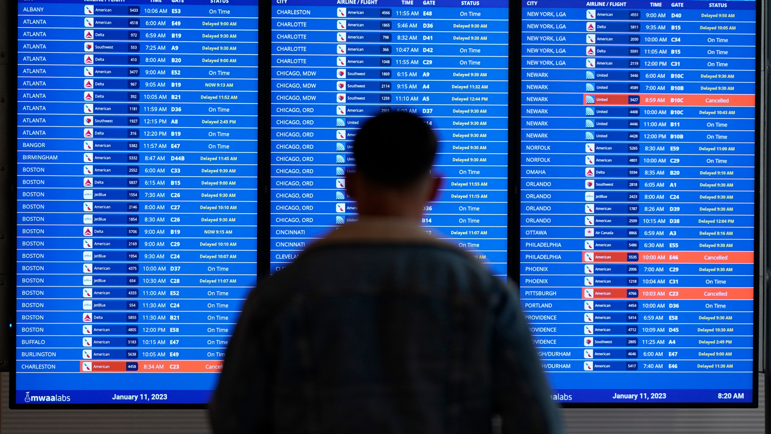 FILE - A traveler looks at a flight board with delays and cancellations at Ronald Reagan Washington National Airport in Arlington, Va., Wednesday, Jan. 11, 2023. Thousands of air travelers faced flight cancellations and delays this weekend as thunderstorms traveled across the U.S. East Coast and Midwest. (AP Photo/Patrick Semansky, File)