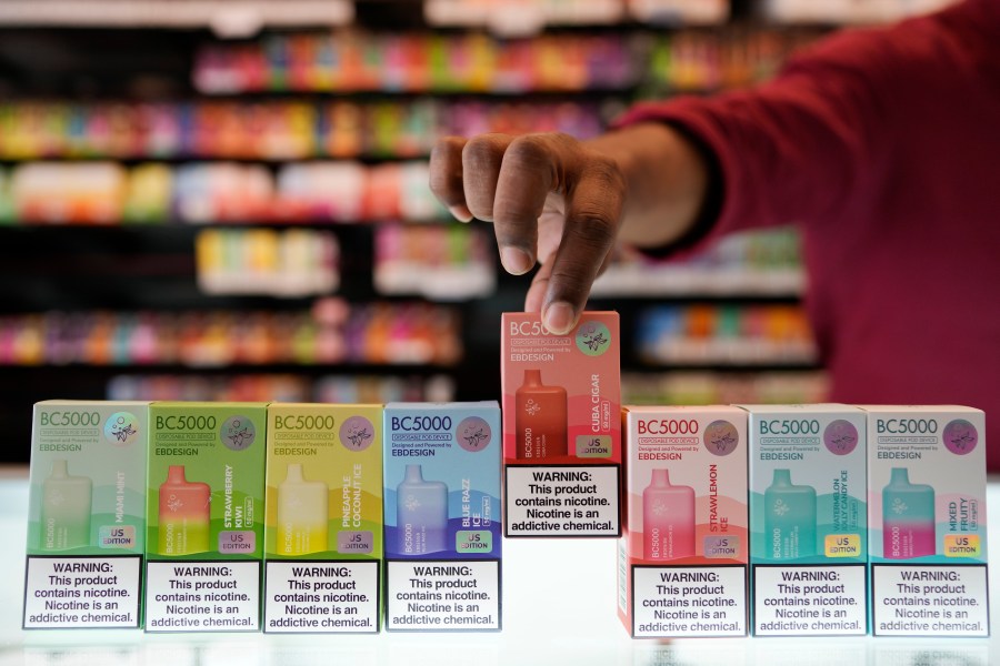 An employee displays some of the varieties of disposable electronic cigarette devices manufactured by EB Design, formerly known as Elf Bar, at Vapes N Smoke in Pinecrest, Fla., Monday, June 26, 2023. Since 2020, the number of different e-cigarette devices for sale in the U.S. has exploded to more than 9,000, a nearly three-fold increase driven almost entirely by a wave of disposable vapes from China. (AP Photo/Rebecca Blackwell)