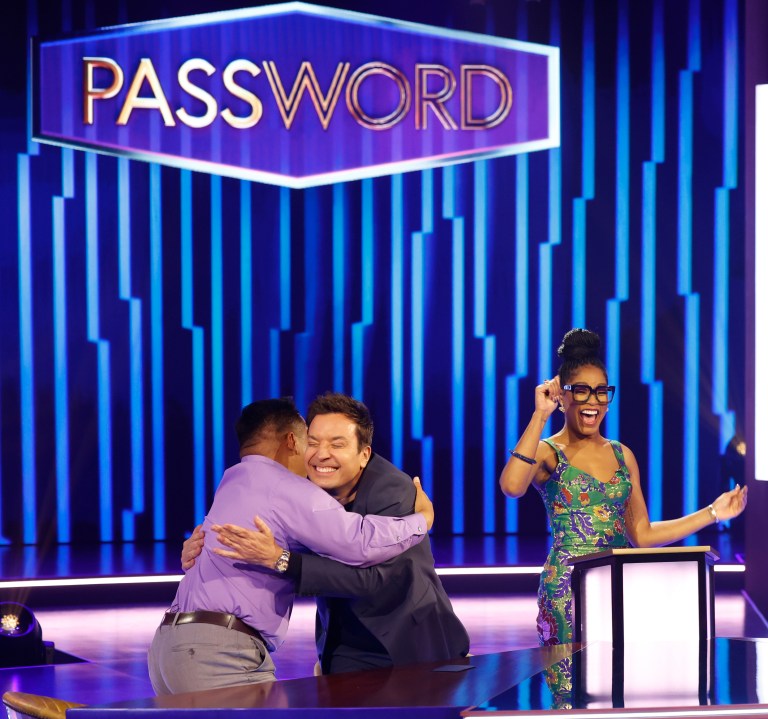 This image released by NBC shows Jimmy Fallon, center, embracing a contestant as host Keke Palmer, looks on, during the game show "Password." (Jordin Althaus/NBC via AP)