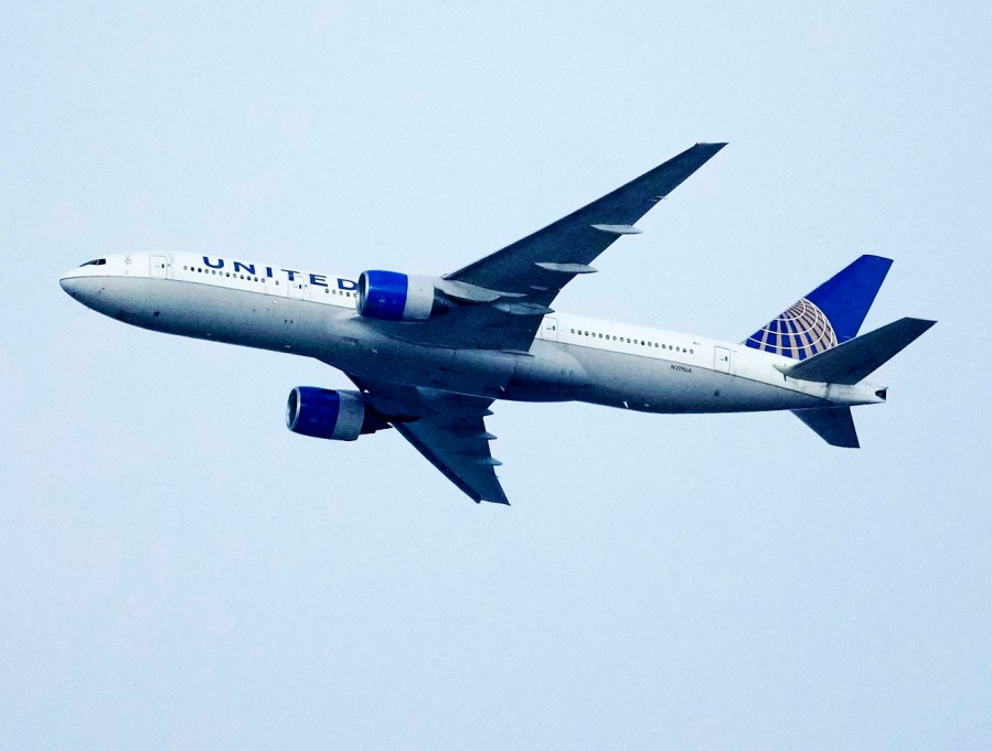 FILE - A United Airlines jetliner soars past an MLS soccer match July 8, 2023, in Commerce City, Colo. United Airlines and the union representing its pilots said Saturday, July 15, 2023, they reached agreement on a contract that will raise pilot pay by up to 40% over four years. (AP Photo/David Zalubowski, File)