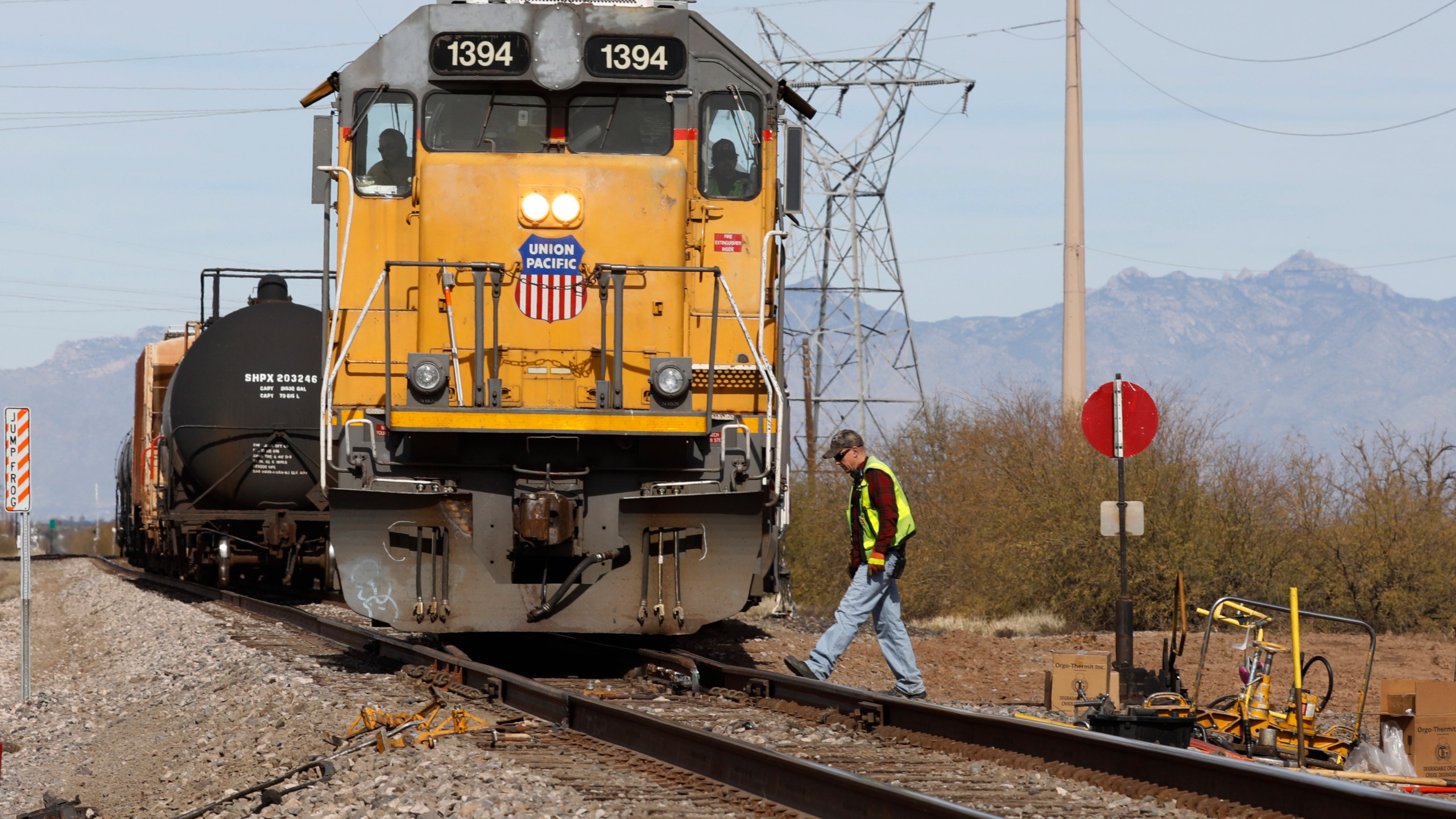 FILE - The crew on a Union Pacific freight train works at a siding area, Jan. 24, 2020, south of Tucson, Ariz. Union Pacific will renew its push for one-person train crews later this summer when the railroad tests out the idea of having a conductor in a truck respond to problems on trains in Nebraska and Colorado. UP's Jason Pinder confirmed the pilot program on Monday, July 17, 2023, when he testified against a proposed Kansas rule that would require two-person crews. (AP Photo/David Boe, File)