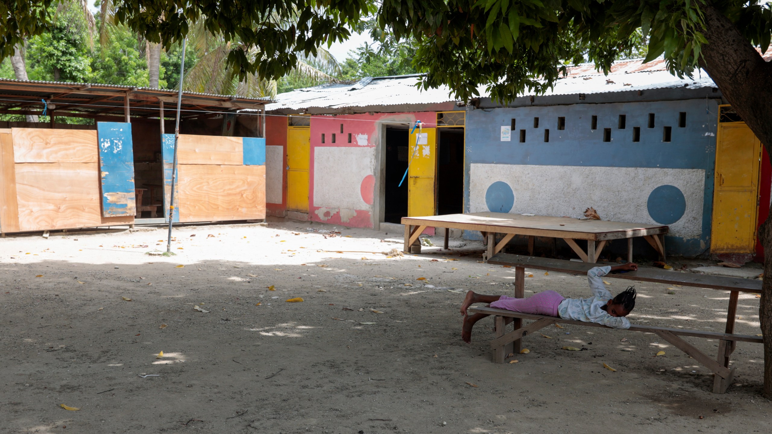 A girl rests in the courtyard of the school funded by El Roi Haiti in the Cite Soleil neighborhood of Port-au-Prince, Haiti, Monday, July 31, 2023. The non profit organization said in a statement that Alix Dorsainvil, a nurse who works for El Ron Haiti, and her daughter were kidnapped July 27. (AP Photo/Odelyn Joseph)