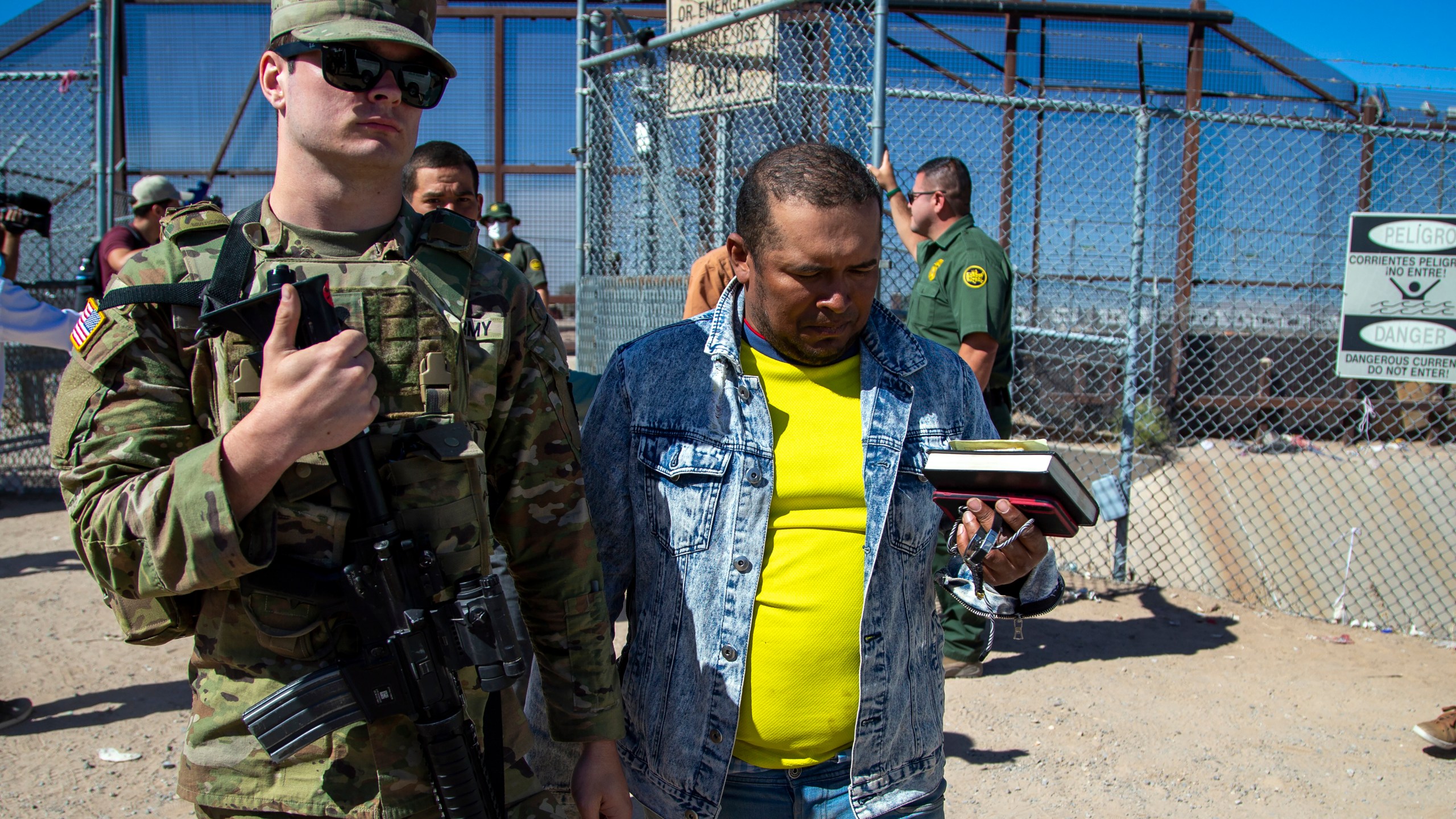 FILE - Migrants are escorted by a U.S. Army soldier after entering into El Paso, Texas from Ciudad Juarez, Mexico to be processed by immigration authorities, May 10, 2023. The Pentagon is pulling 1,100 active duty troops from the U.S.-Mexico border it deployed earlier this year as the government prepares for the end of asylum restrictions linked to the pandemic. (AP Photo/Andres Leighton, File)