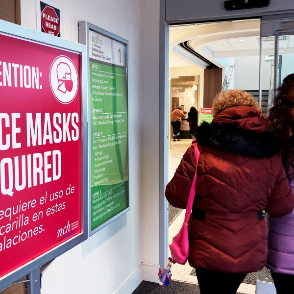 A sign announcing a face mask requirement is displayed at a hospital in Buffalo Grove, Ill., Friday, Jan. 13, 2023. COVID-19 hospital admissions are inching upward in the United States since early July 2023. It's a small-scale echo of the three previous summers. (AP Photo/Nam Y. Huh)