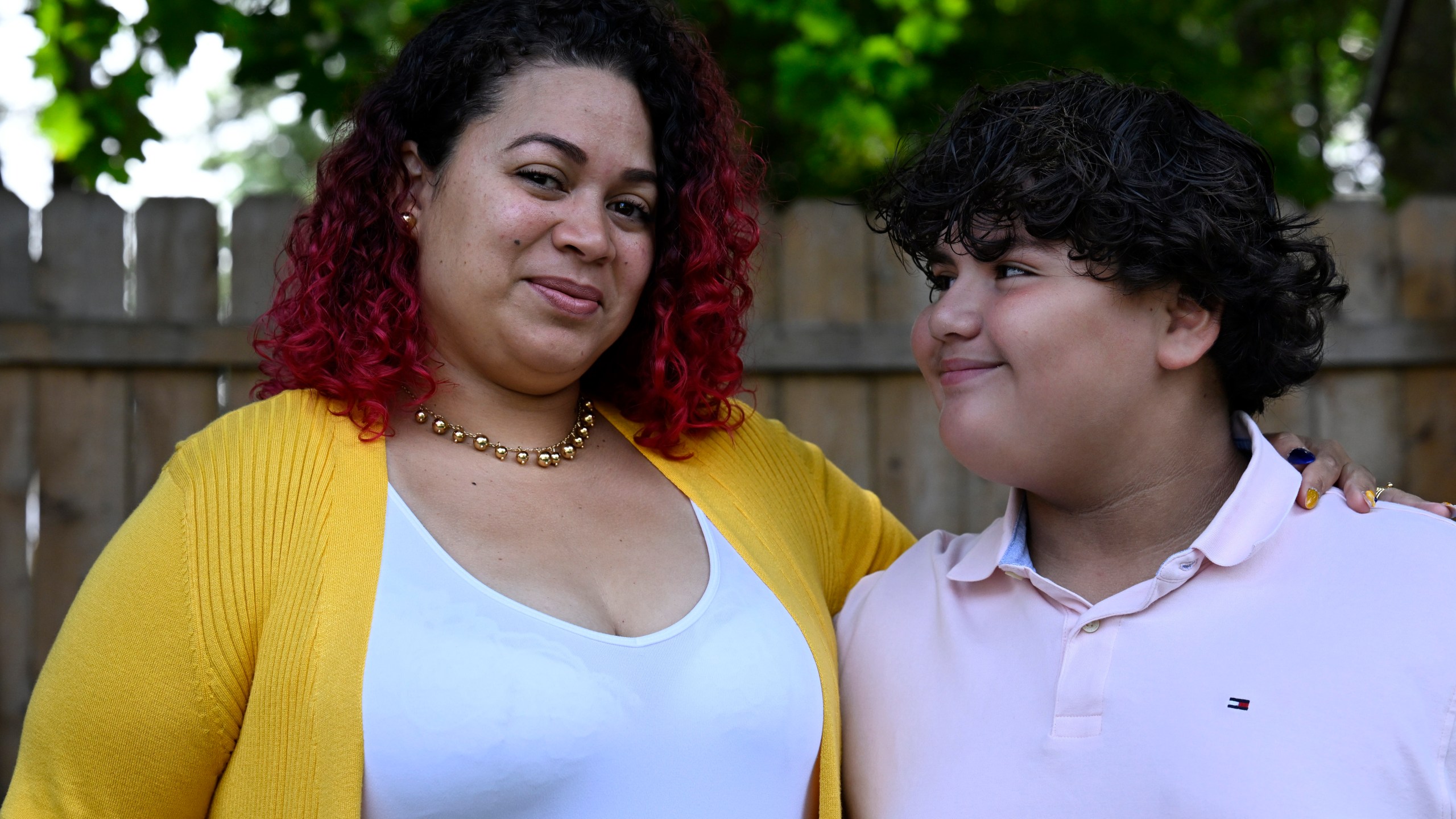 Rousmery Negrón stands with her son at home in Springfield, Mass., on Thursday, Aug. 3, 2023. When in-person school resumed after pandemic closures, Negrón and her son both noticed a change: School seemed less welcoming. Parents were no longer allowed in the building without an appointment, Negrón said. Punishments were more severe. Everyone seemed less tolerant, more angry. Negrón's son even overheard a teacher mocking his learning disabilities, calling him an ugly name. He would end up missing more than five months of sixth grade. (AP Photo/Jessica Hill)