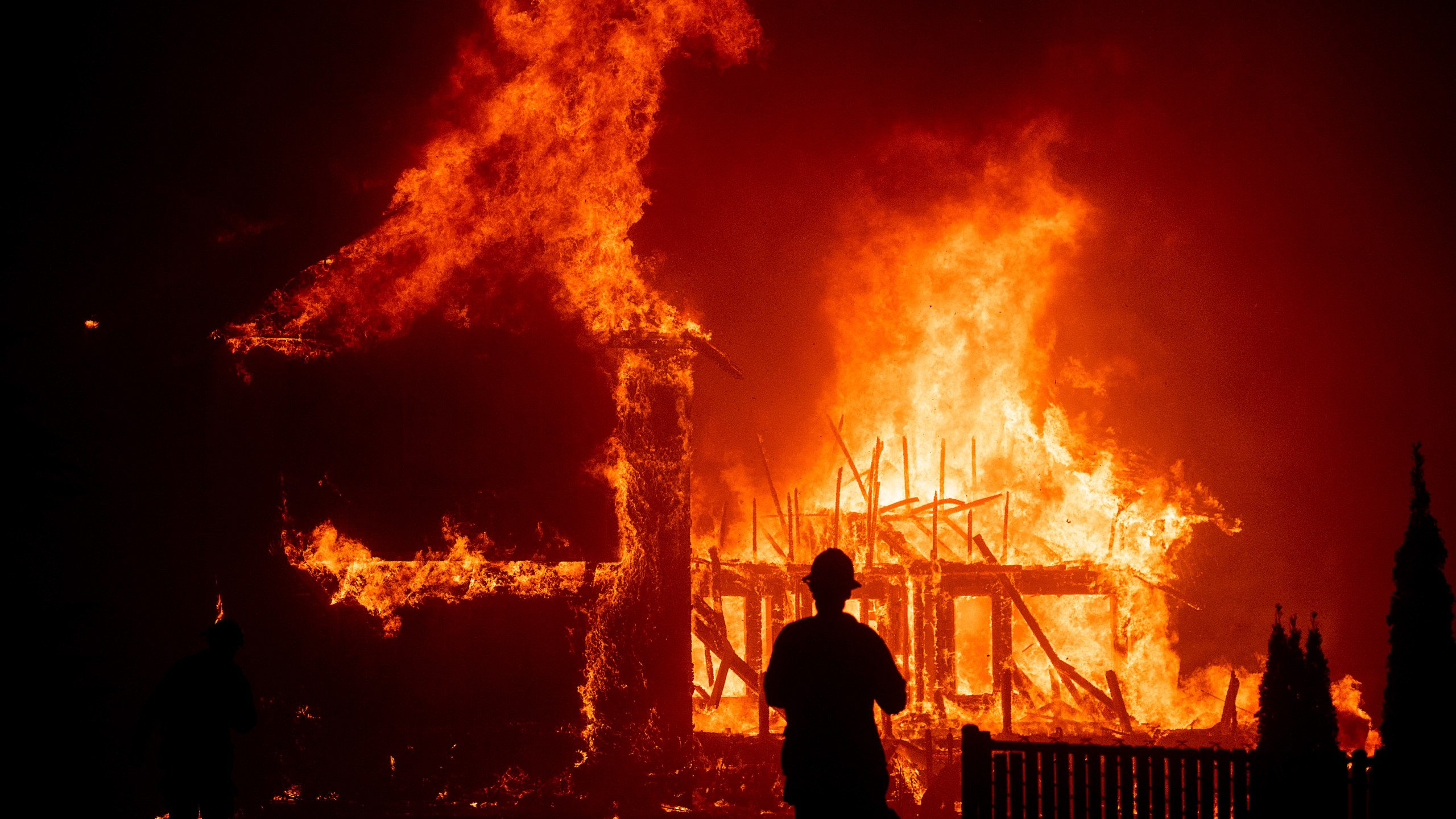 FILE - A home burns as the Camp Fire rages through Paradise, Calif., on Nov. 8, 2018. The Camp Fire bears many similarities to the deadly wildfire in Hawaii. Both fires moved so quickly residents had little time to escape. (AP Photo/Noah Berger)