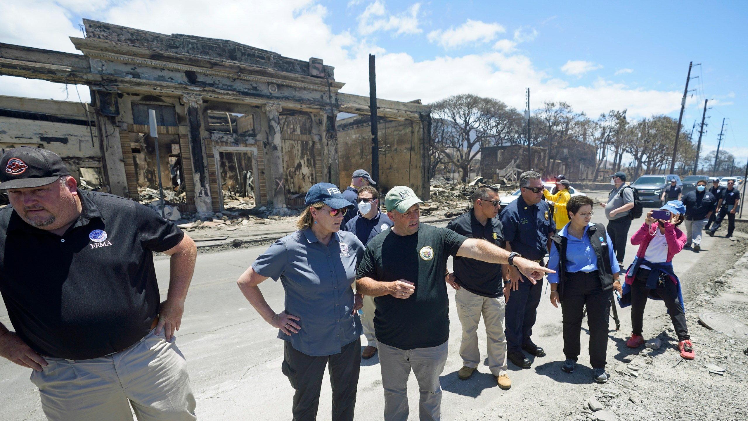 FILE - Hawaii Gov. Josh Green, center, points to damage as he speaks with Federal Emergency Management Agency Administrator Deanne Criswell during a tour of wildfire damage, Saturday, Aug. 12, 2023, in Lahaina, Hawaii. On Friday, Aug. 18, FEMA said it approved $2.3 million in assistance to roughly 1,300 households in Maui so far, as the federal government tries to help survivors of the devastating wildfires. (AP Photo/Rick Bowmer, File)