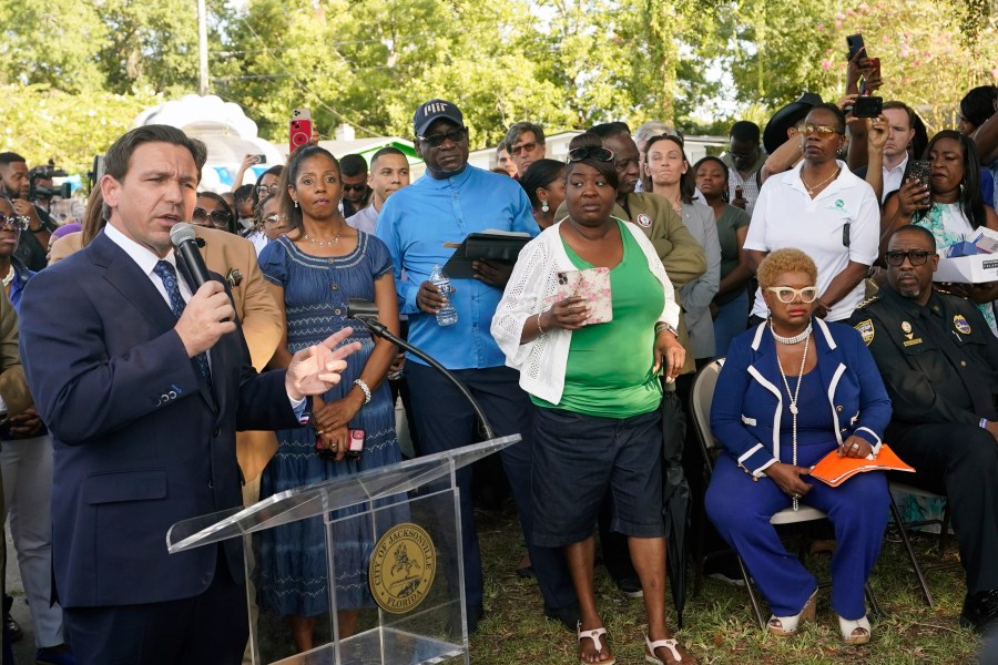 Florida Gov. Ron DeSantis, left, speaks at a prayer vigil for the victims of a mass shooting a day earlier, in Jacksonville, Fla., Sunday, Aug. 27, 2023. (AP Photo/John Raoux)