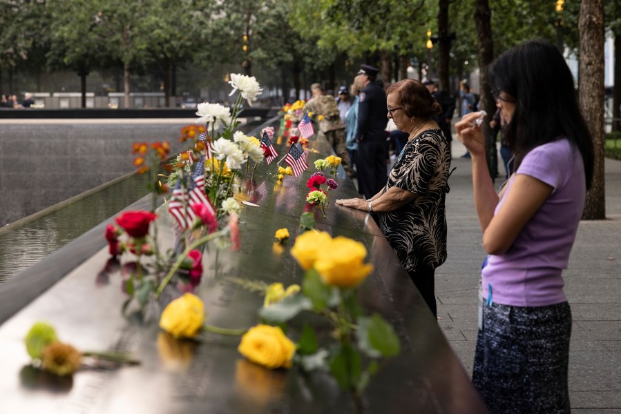 Family members put hands on the 9/11 Memorial during the commemoration ceremony on the 22nd anniversary of the September 11, 2001, terror attacks on Monday, Sept. 11, 2023, in New York. (AP Photo/Yuki Iwamura)