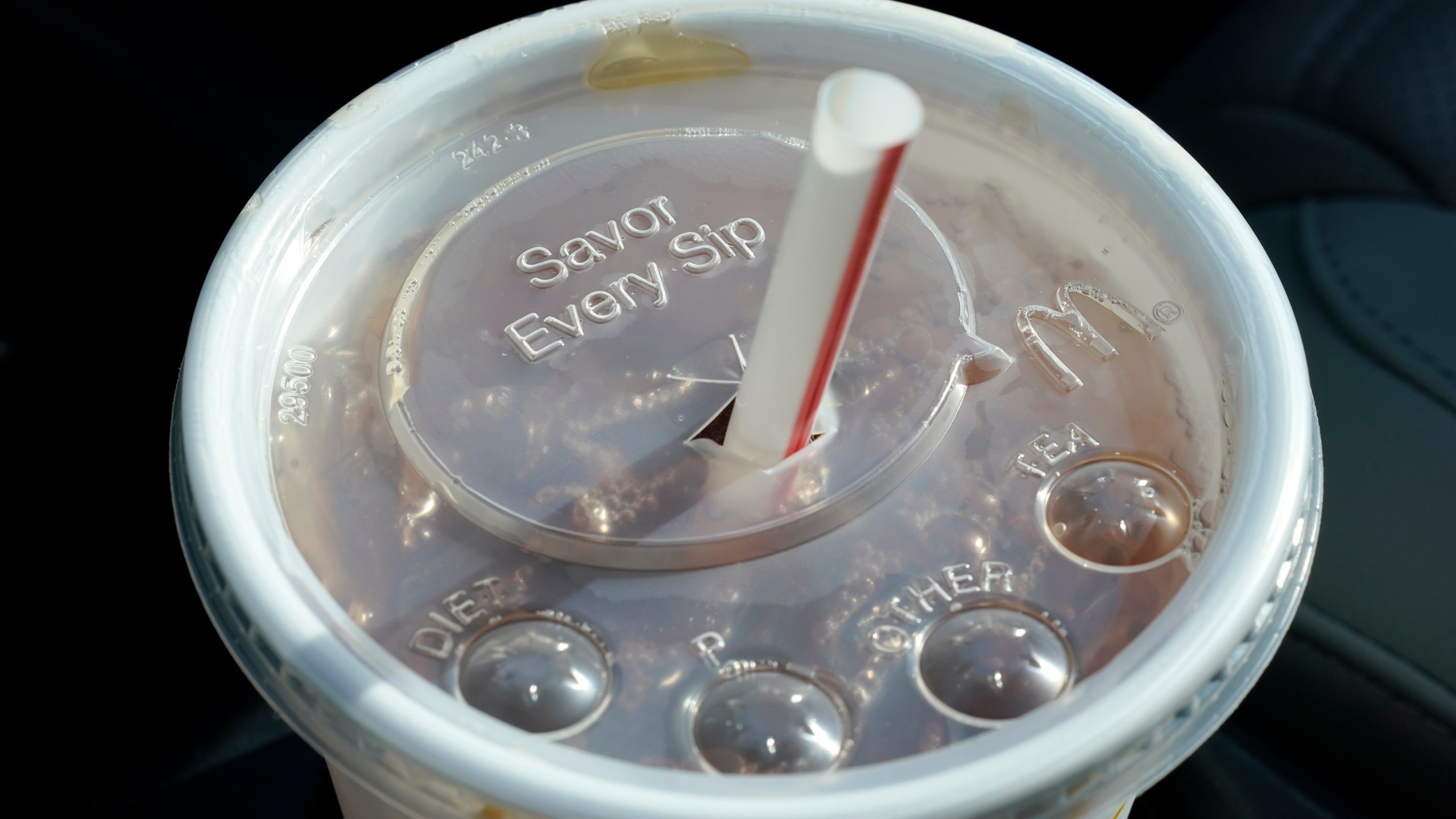 FILE - A McDonald's beverage sits in a cup holder, April 27, 2021, in Des Moines, Iowa. McDonald's plans to eliminate self-service soda machines at all of its U.S. restaurants by 2032, the Chicago-based fast food chain has confirmed. In an email to The Associated Press on Tuesday, Sept. 12, 2023, McDonald's USA said the goal of the change is to create consistency for customers and crew members across the chain's offerings — from in-person dining to online delivery and drive-thru options. (AP Photo/Charlie Neibergall, File)