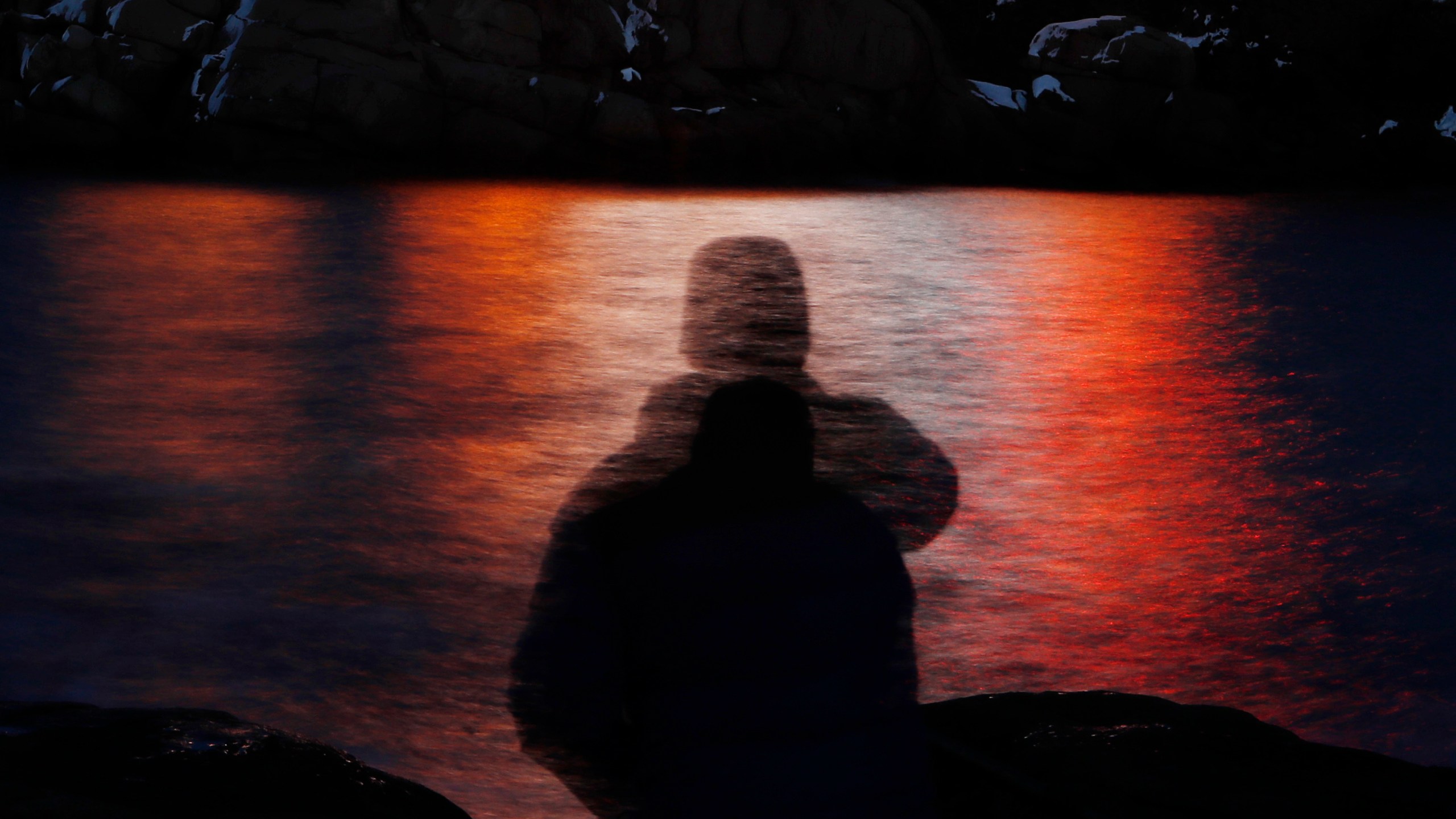 FILE - In this photo made with a long exposure, a man is silhouetted against lights reflected in the waters off Cape Neddick in Maine on Dec. 11, 2017. A study published Thursday, Sept. 14, 2023, in the journal Nature Medicine has found that the psychedelic drug MDMA, combined with talk therapy, can reduce symptoms of post-traumatic stress disorder. (AP Photo/Robert F. Bukaty, File)