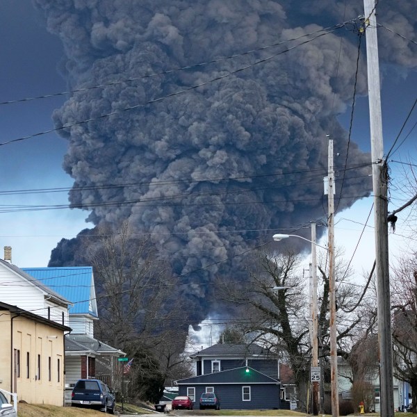 A black plume rises over East Palestine, Ohio, as a result of a controlled detonation of a portion of the derailed Norfolk Southern trains.