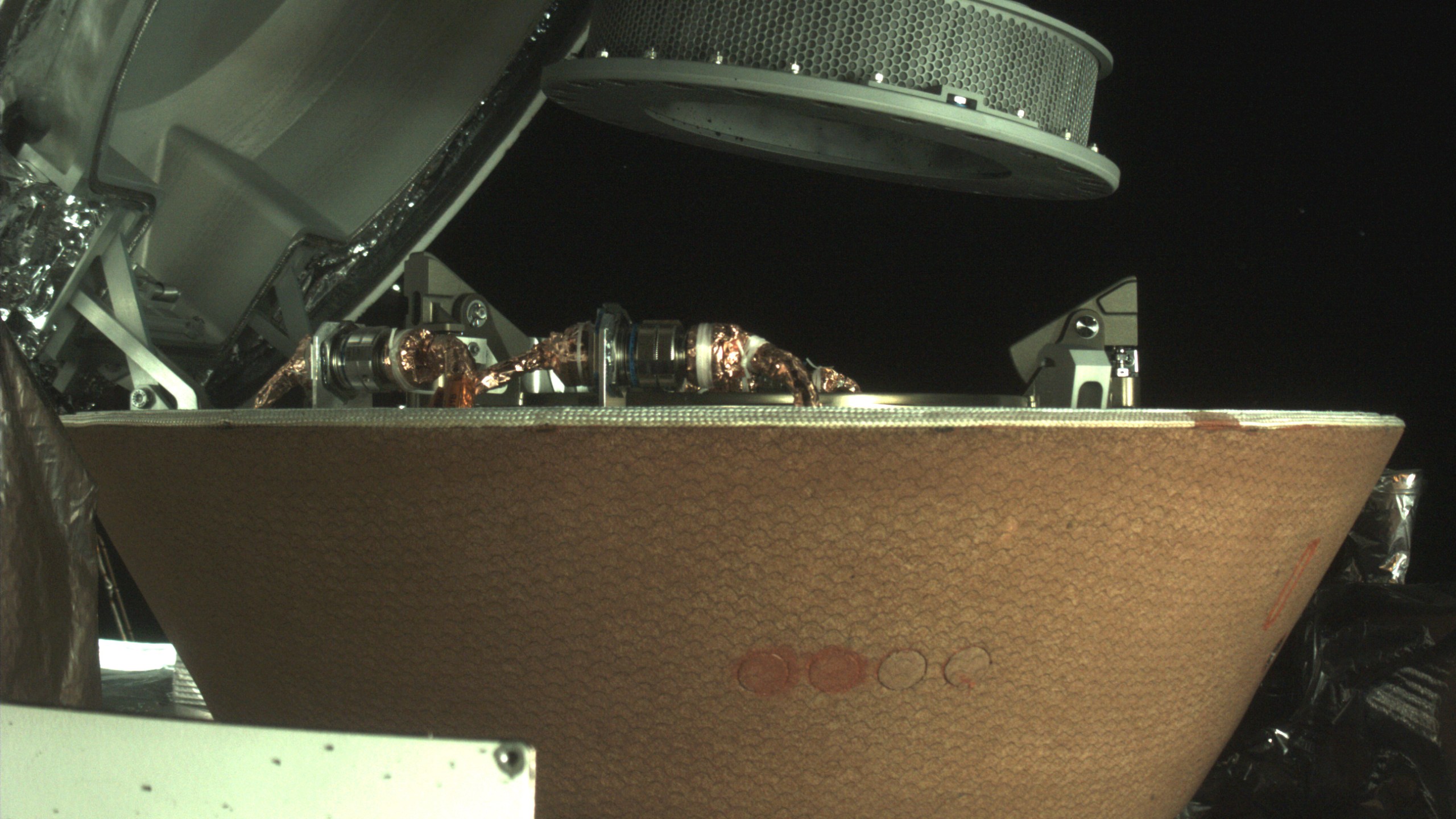 FILE - In this undated image provided by NASA, a sample container hovers over a capsule on the OSIRIS-REx spacecraft near the asteroid Bennu. On Sunday, Sept. 24, 2023, the OSIRIS-REx spacecraft will fly by Earth and drop off what is expected to be at least a cupful of rubble it grabbed from the asteroid Bennu, closing out a seven-year quest. (NASA via AP, File)