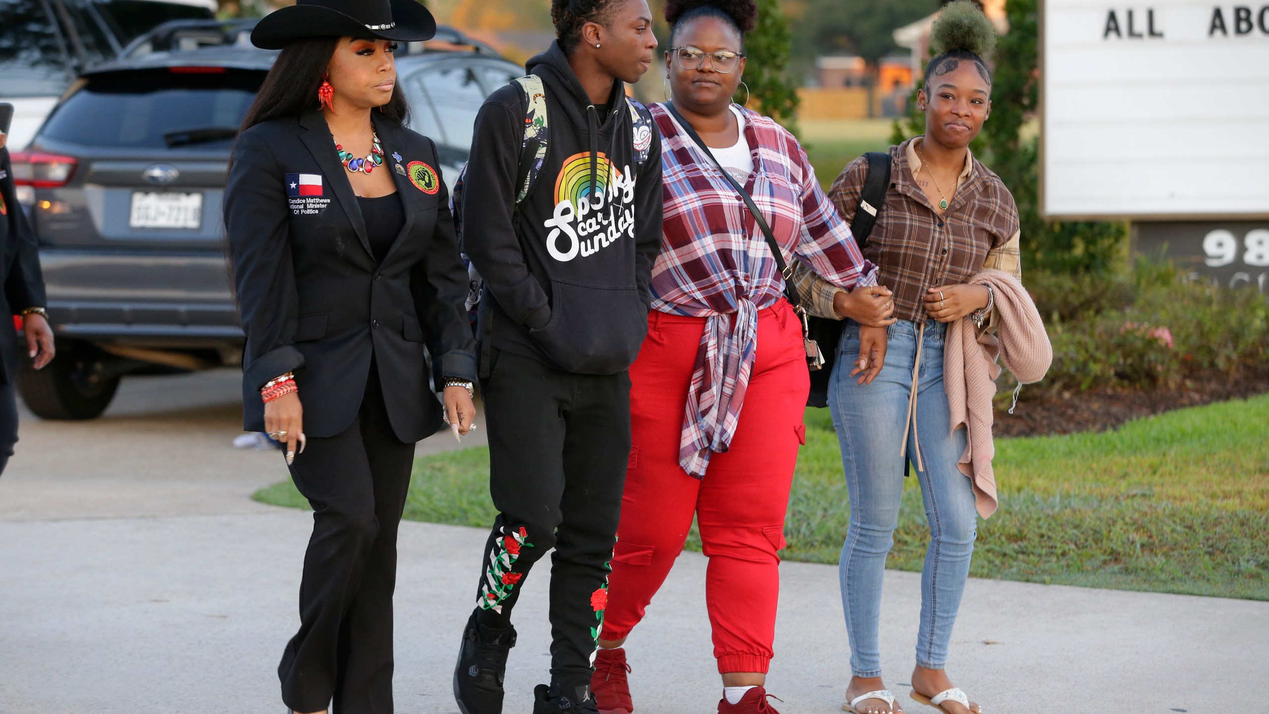 Candice Matthews, left, National minister of politics for the New Black Panther Nation; Darryl George, center left, a 17-year-old junior, and his mother Darresha George, center right, and a unidentified female, right, begin their walk across the street to go into Barbers Hill High School after Darryl served a 5-day in-school suspension for not cutting his hair Monday, Sept. 18, 2023, in Mont Belvieu. (AP Photo/Michael Wyke)