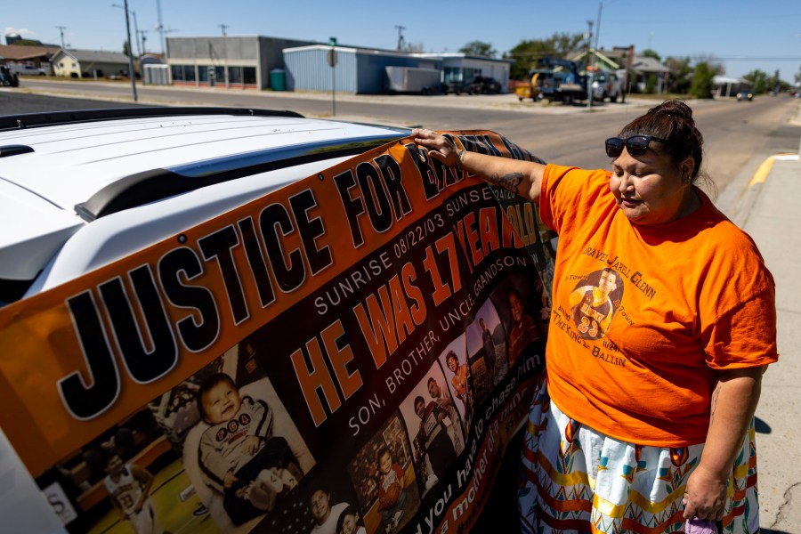 Blossom Old Bull holds up a banner for her son which says "justice for Braven Glenn," during a rally in support of the Missing and Murdered Indigenous People movement at the Big Horn County Building on Tuesday, Aug. 29, 2023, in Hardin, Mont. Glenn was killed while being pursued by a Crow Tribal Police officer. The Crow Tribal Police Department has since been disbanded and Old Bull has been critical of the amount of information she has received regarding the circumstances of her son's death. (AP Photo/Mike Clark)